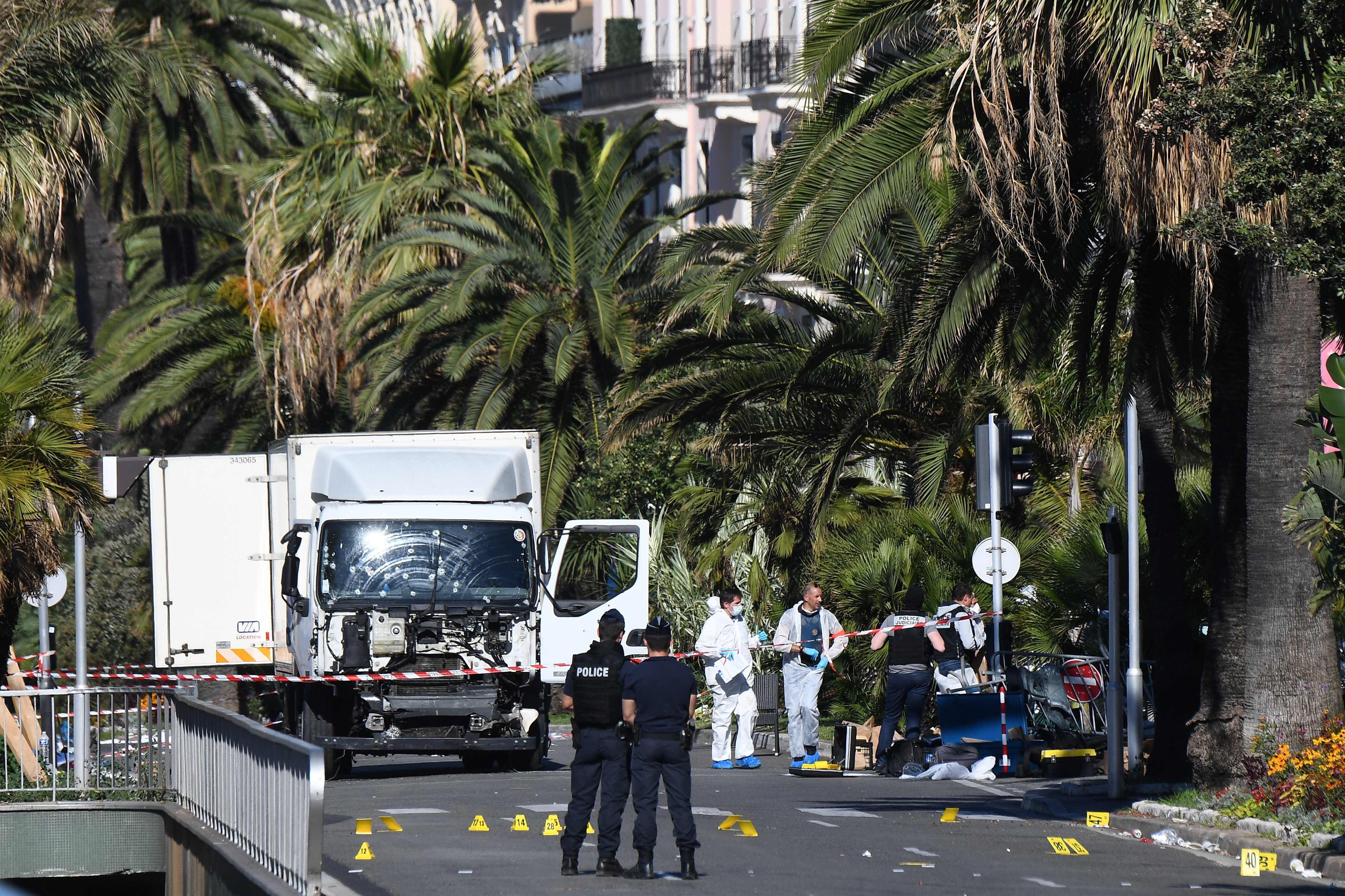 En esta foto de archivo, oficiales forenses y policías buscan evidencias cerca de un camión en el paseo marítimo Promenade des Anglais en la ciudad de Niza en la Riviera francesa el 15 de julio de 2016, después de que atropelló a una multitud que miraba un espectáculo de fuegos artificiales. (FOTO AFP / ANNE-CHRISTINE POUJOULAT)