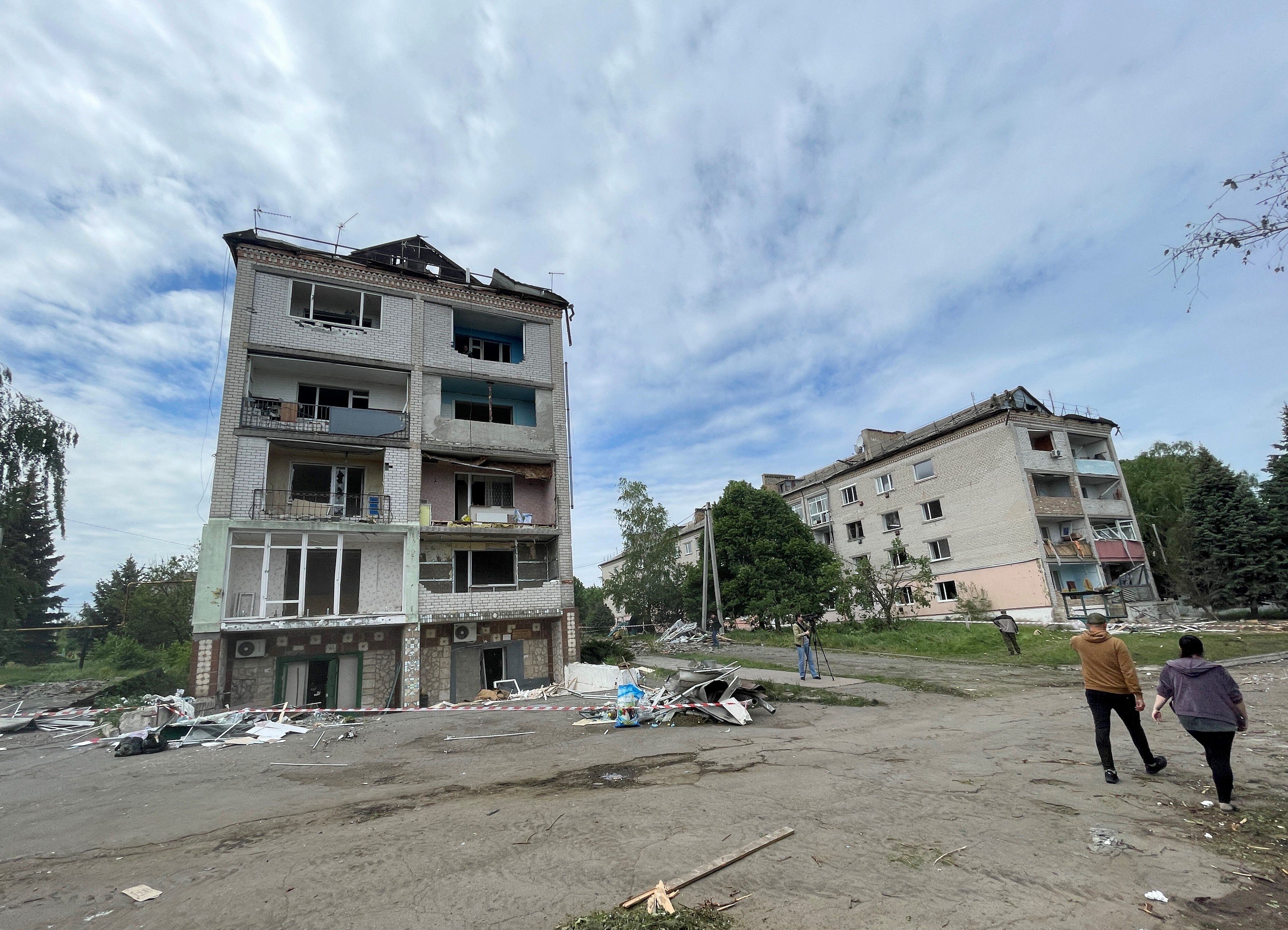 La gente pasa frente a un edificio residencial dañado luego de un ataque ruso en un pequeño pueblo en la región de Dnipropetrovsk.