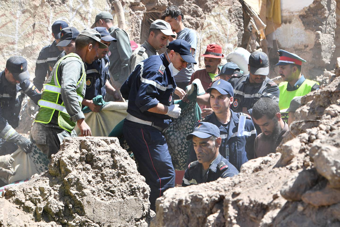 Los socorristas evacuan un cuerpo de debajo de los escombros en la aldea de Tiksit, al sur de Adassil,