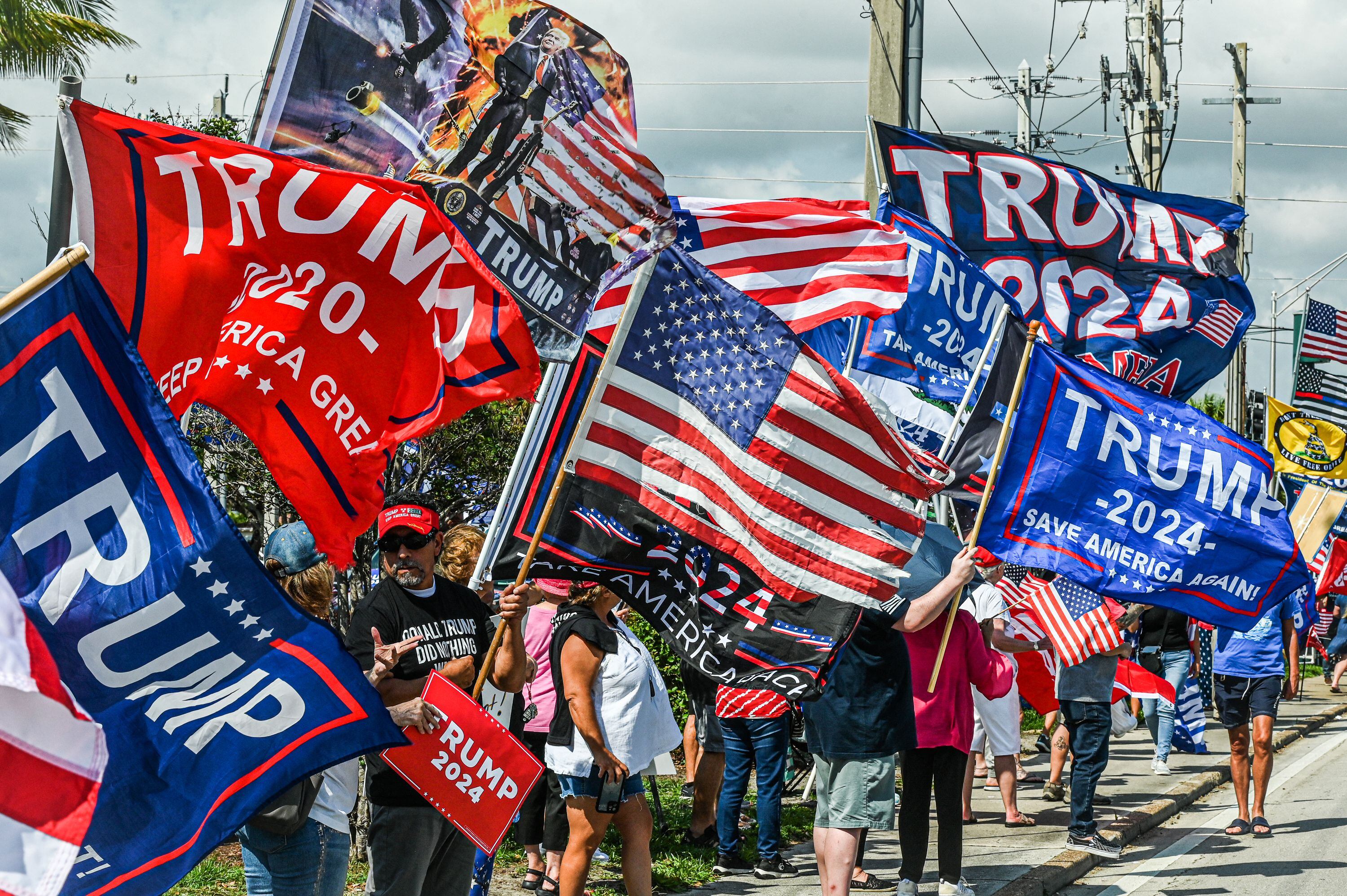 Decenas de simpatizantes del expresidente de los Estados Unidos, Donald Trump, esperan la caravana que lo llevará al Aeropuerto Internacional de Palm Beach en West Palm Beach, Florida.