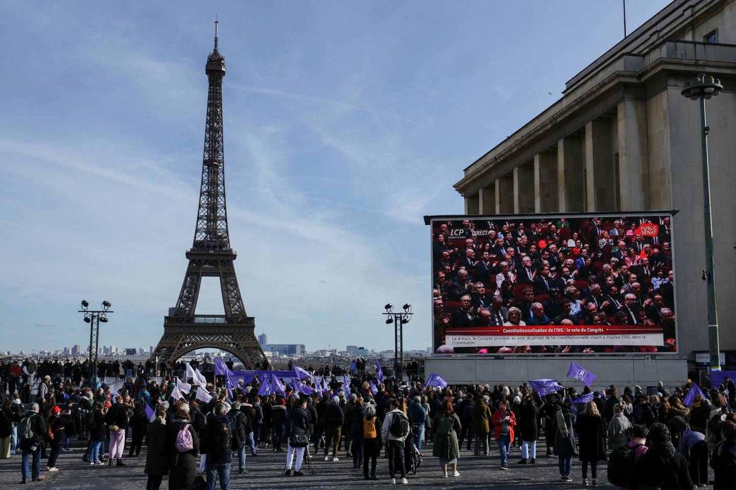 La gente se reúne cerca de la Torre Eiffel en la Place du Trocadero de París, durante la retransmisión de la convocatoria de ambas cámaras del parlamento para anclar el derecho al aborto en la constitución del país.