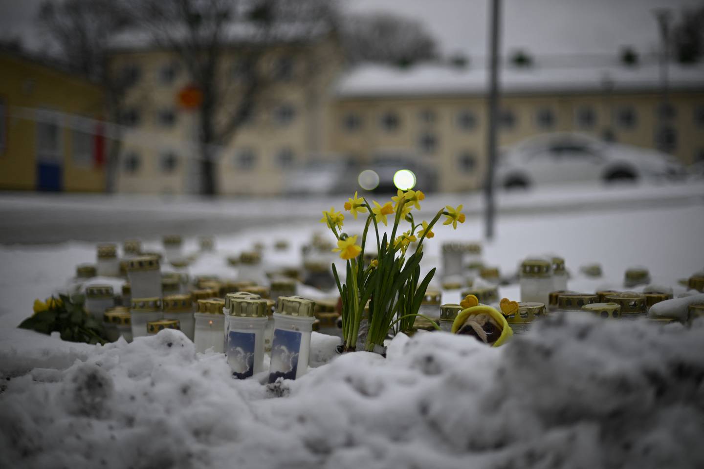 Se colocan velas y flores en la nieve frente a la escuela Viertola para rendir homenaje a las víctimas en Vantaa, en el norte de la capital finlandesa, Helsinki.  (Foto de Olivier MORIN / AFP)