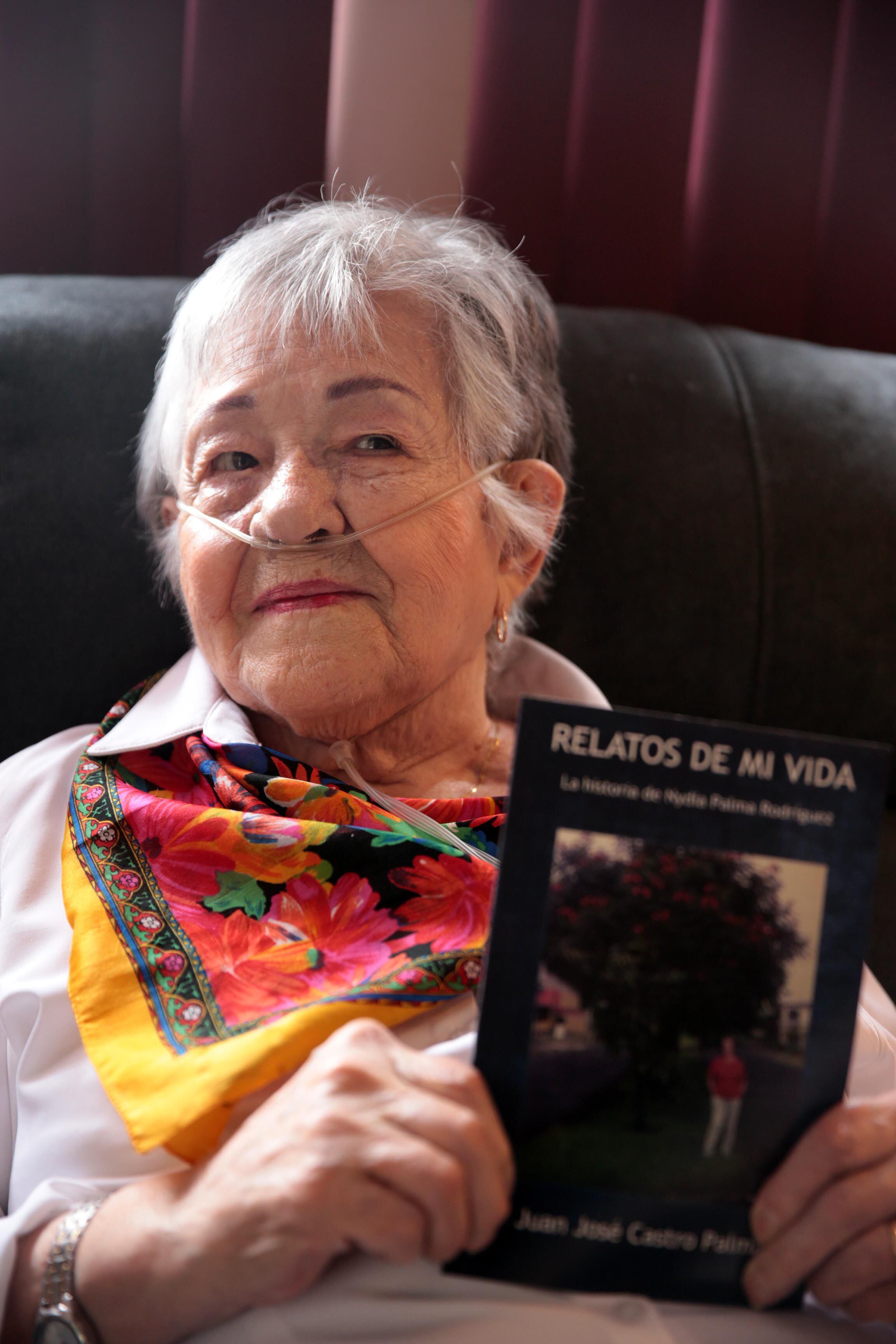 Doña Nidya muestra el libro que revela los momentos más significativos de su vida, entre ellos, sobresale su vínculo con el árbol.