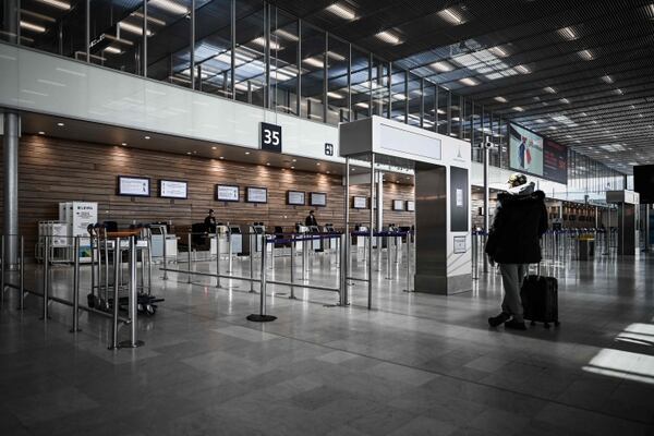 A man waits in front of counters at the deserted international airport of Orly, on March 30, 2020, a day before its closure due to a drop in traffic amid the spread of the COVID-19 infection, caused by the novel coronavirus. (Photo by Philippe LOPEZ / AFP)