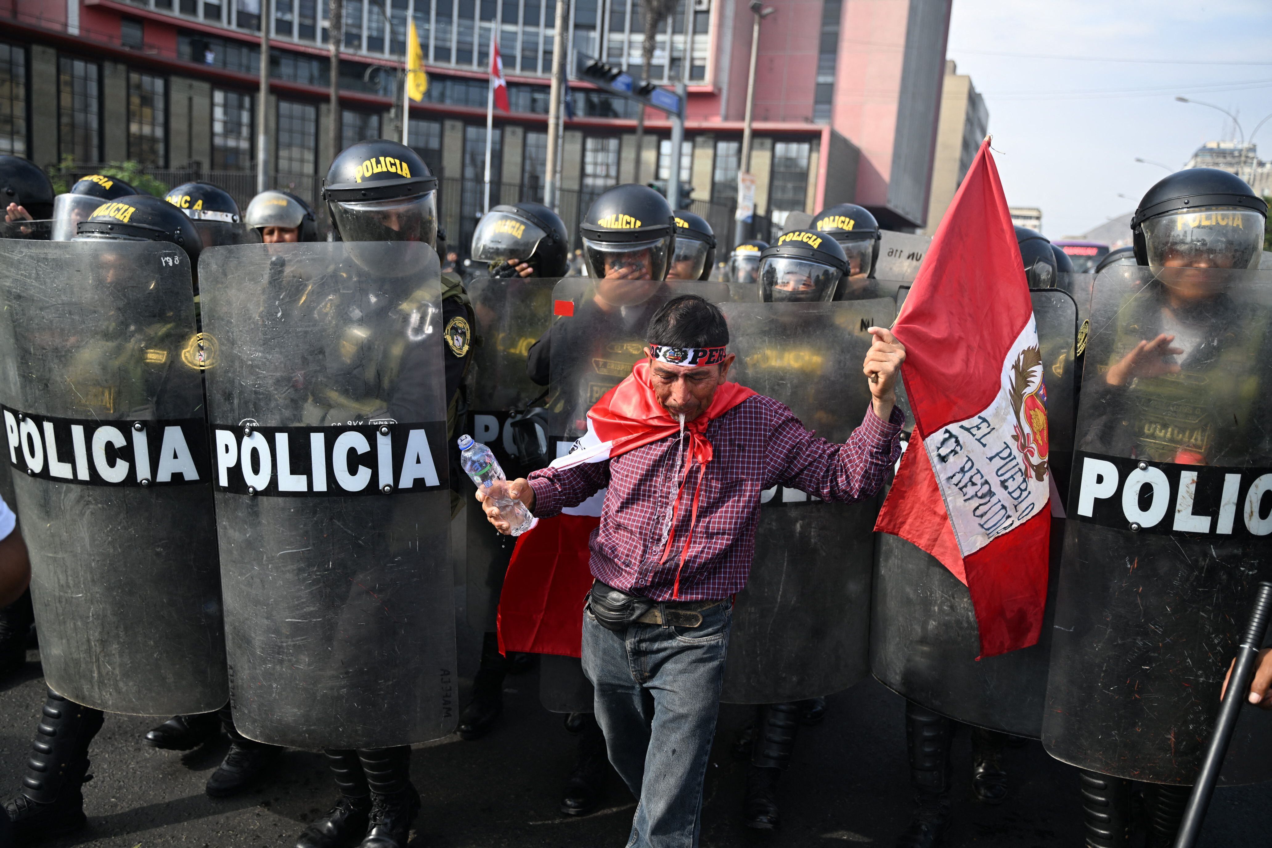 Un manifestante escupe agua frente a la policía durante una protesta contra el gobierno de la presidenta Dina Boluarte en Lima