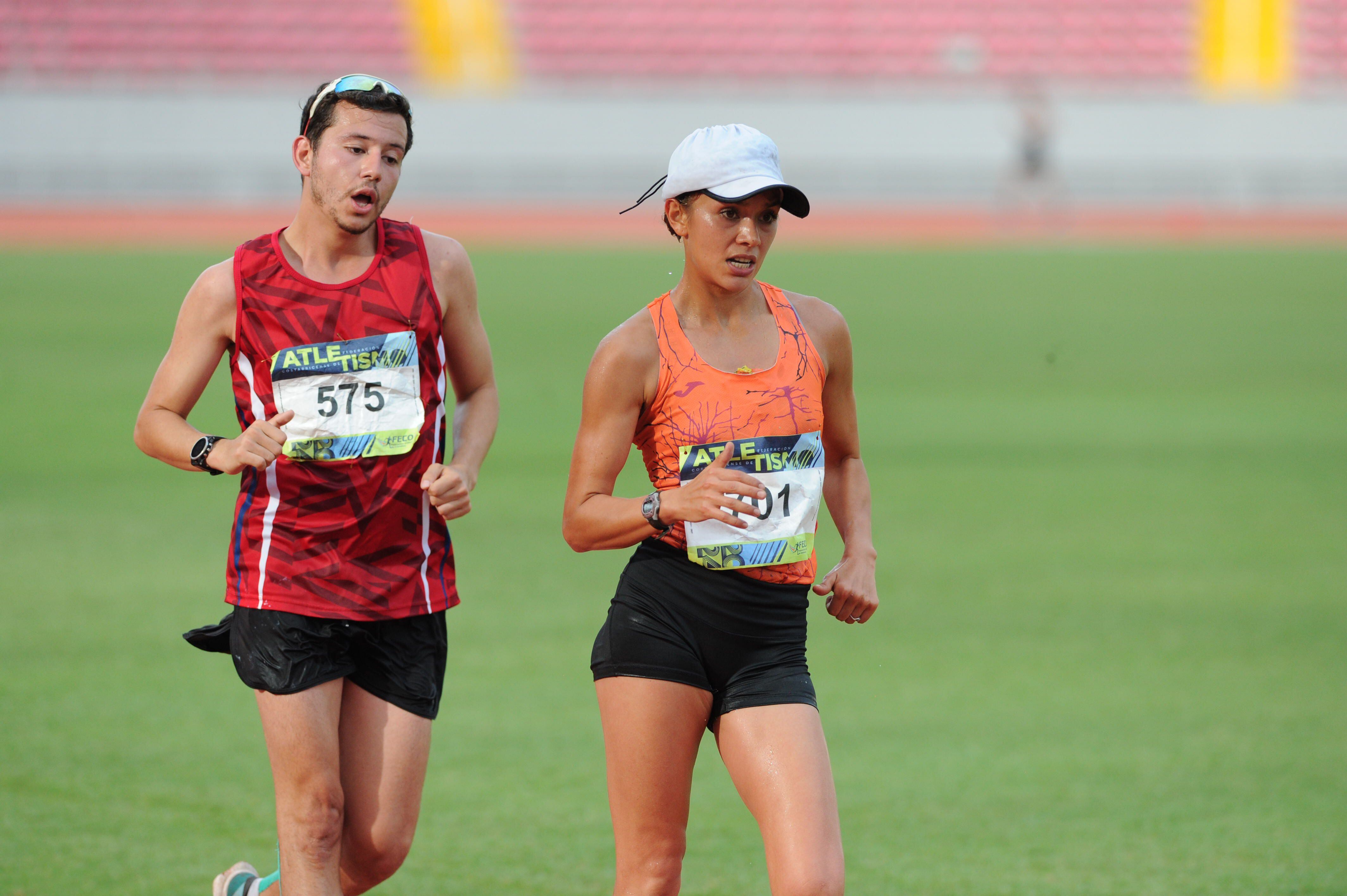 Noelia Vargas impuso un ritmo muy fuete desde el arranque de la prueba de los 20.000 metros marcha. Yeudy Bonilla, del equipo de la UNA, busca seguirle el paso.