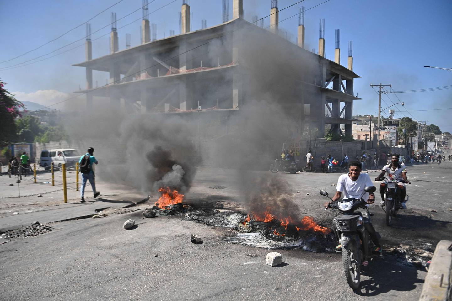 Un motociclista pasa quemando neumáticos en Delmas 30, Puerto Príncipe, Haití, durante un día de levantamiento contra el primer ministro haitiano. Este país del Caribe vive en medio de una crisis, desde el año anterior fue tomado por los grupos criminales. (Foto de Richard PIERRIN / AFP)