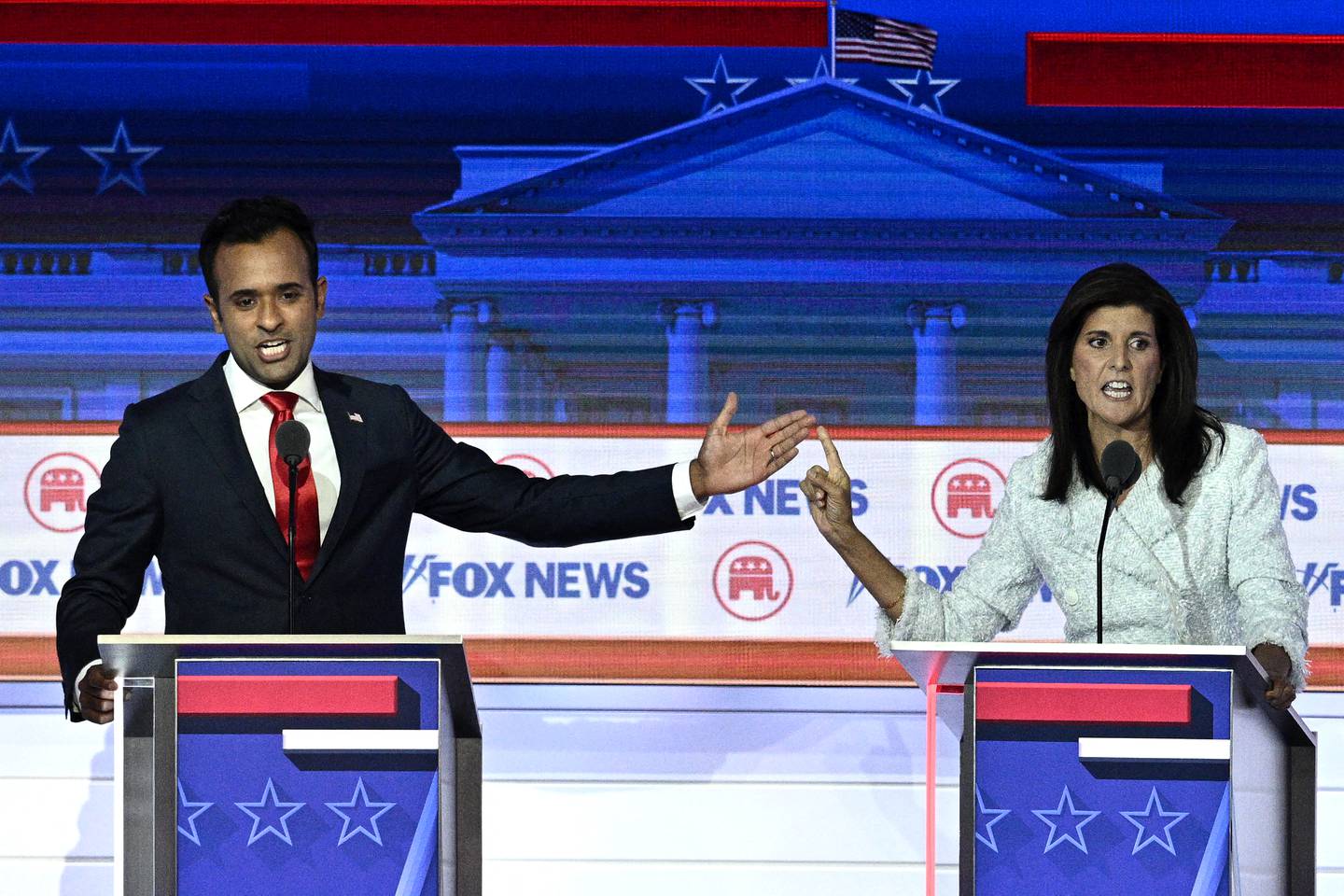 El empresario y autor Vivek Ramaswamy (izq.) y el exgobernador de Carolina del Sur y embajador de la ONU, Nikki Haley, hacen gestos mientras hablan durante el primer debate primario presidencial republicano