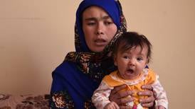 Afganistán se conmueve con la foto de una madre haciendo examen con su hija en brazos