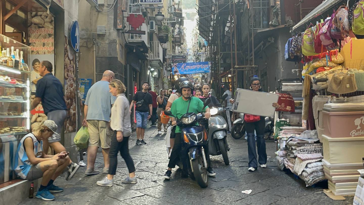 Entre los callejones de la ciudad de Nápoles, es frecuente el paso de las motos vespas.