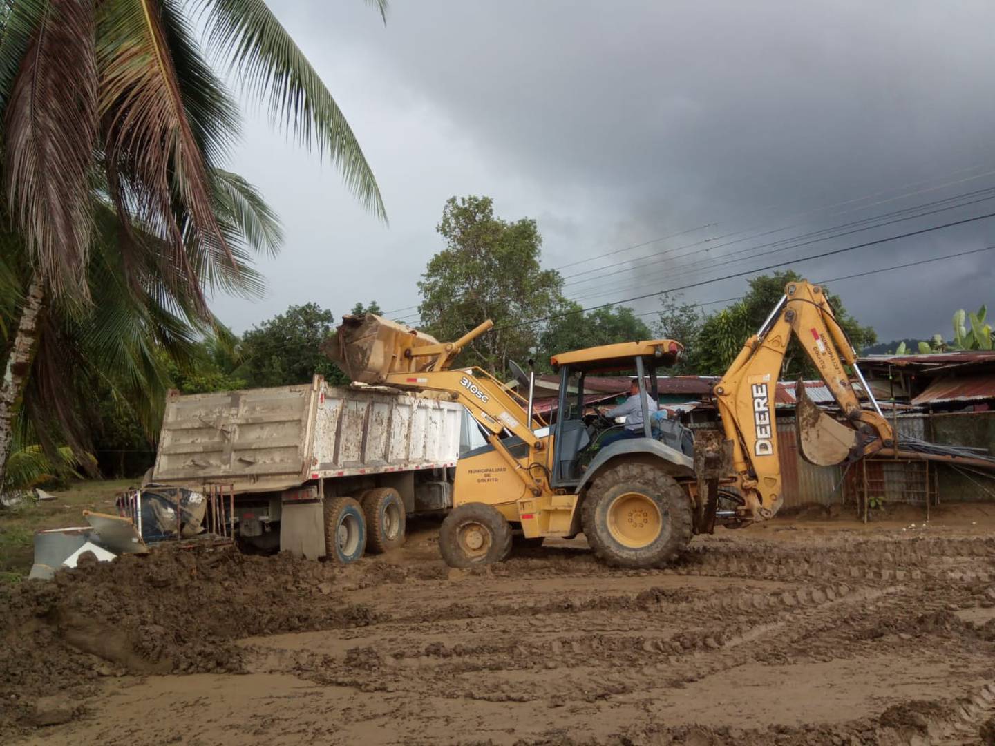 Esta mañana en La Esperanza de Guaycará, Golfito, maquinaria municipal reabría los camino y recogía bienes dañados por el temporal. Al fondo una nube de  cumulonimbos presagiaba más lluvias. Foto: Cortesía Freiner Lara.