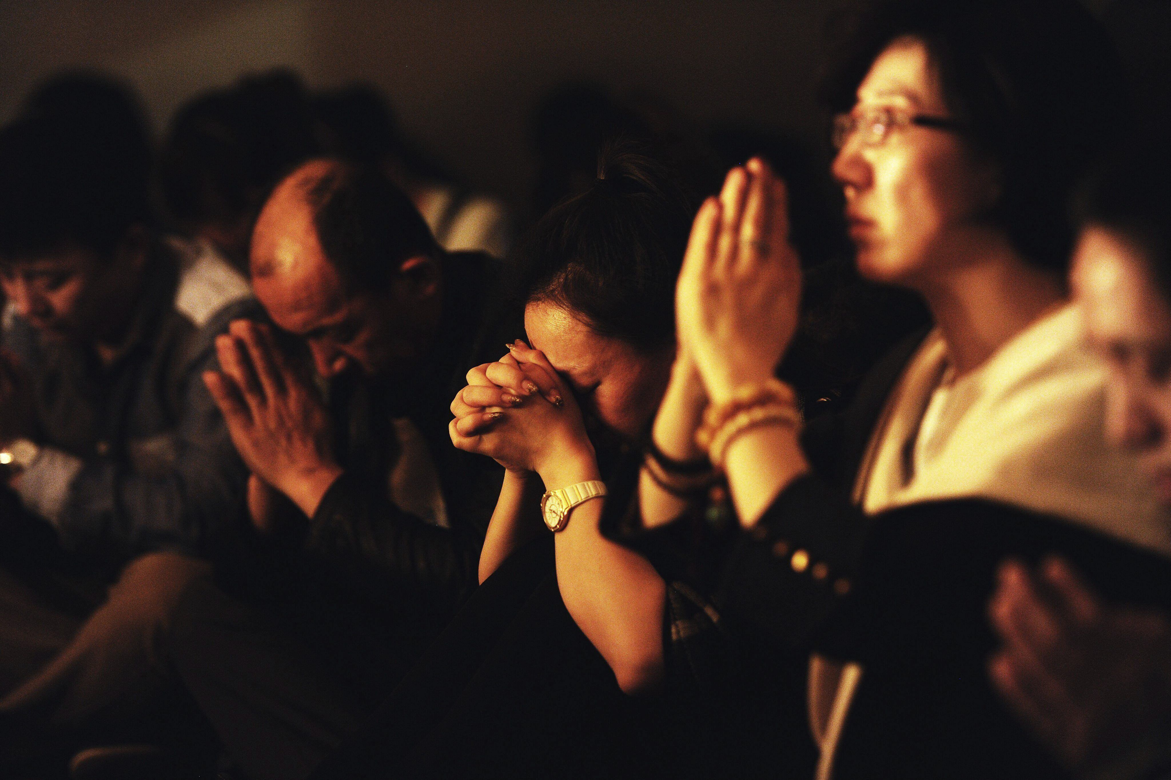 Familiares de los pasajeros del vuelo MH370 ofreciendo oraciones por sus parientes, en Pekín (China) el 24 de marzo de 2014.  Foto: EFE/Mark Wong 