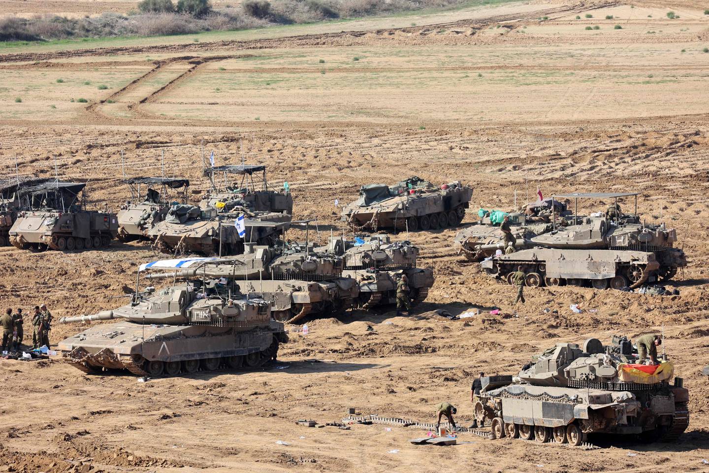 Las tropas israelíes se reúnen con sus vehículos militares en la frontera con la Franja de Gaza.