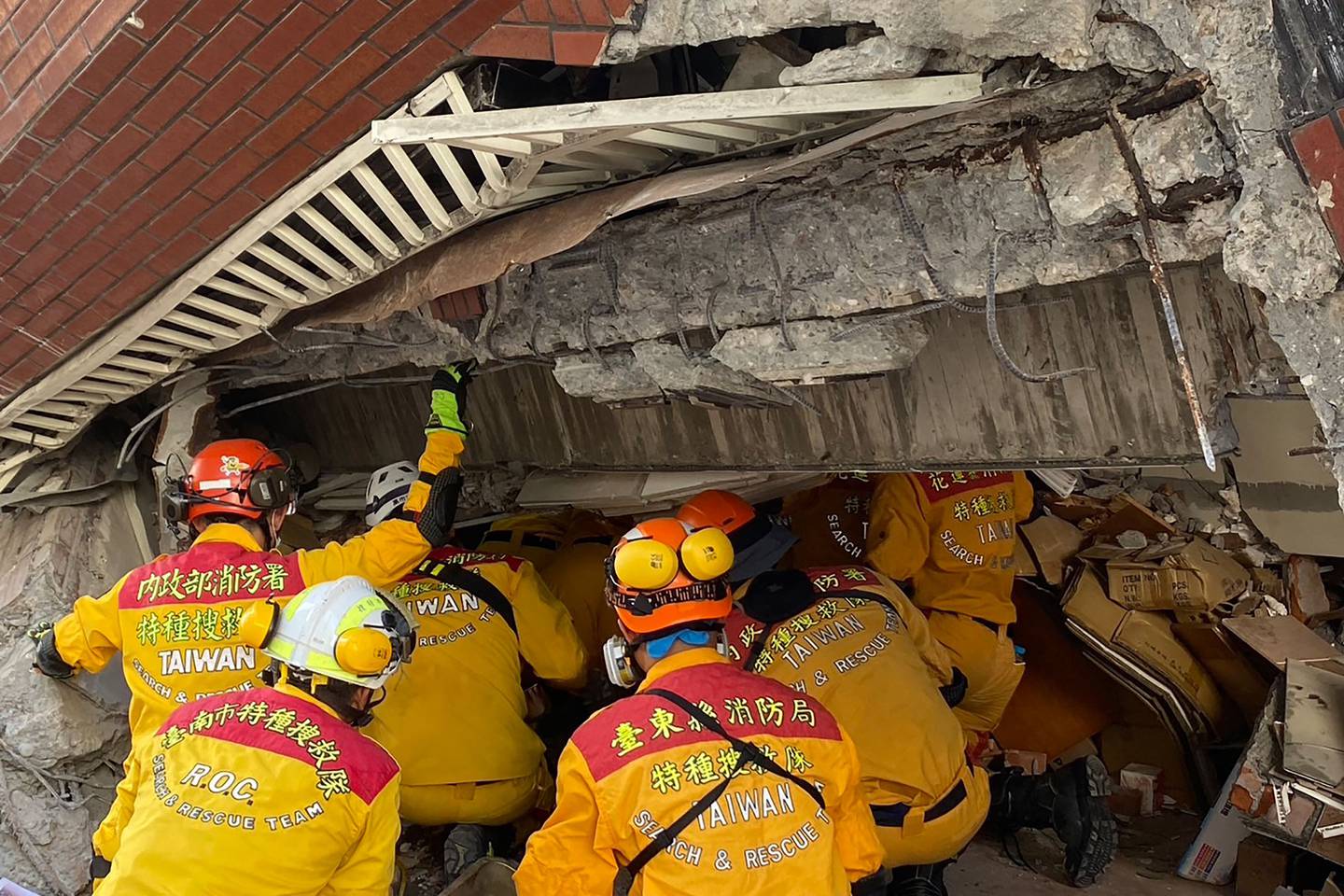 Miembros de un equipo de rescate que busca sobrevivientes en un edificio dañado en Hualien, después de que un gran terremoto azotara el este de Taiwán. Al menos siete personas murieron y más de 700 resultaron heridas.