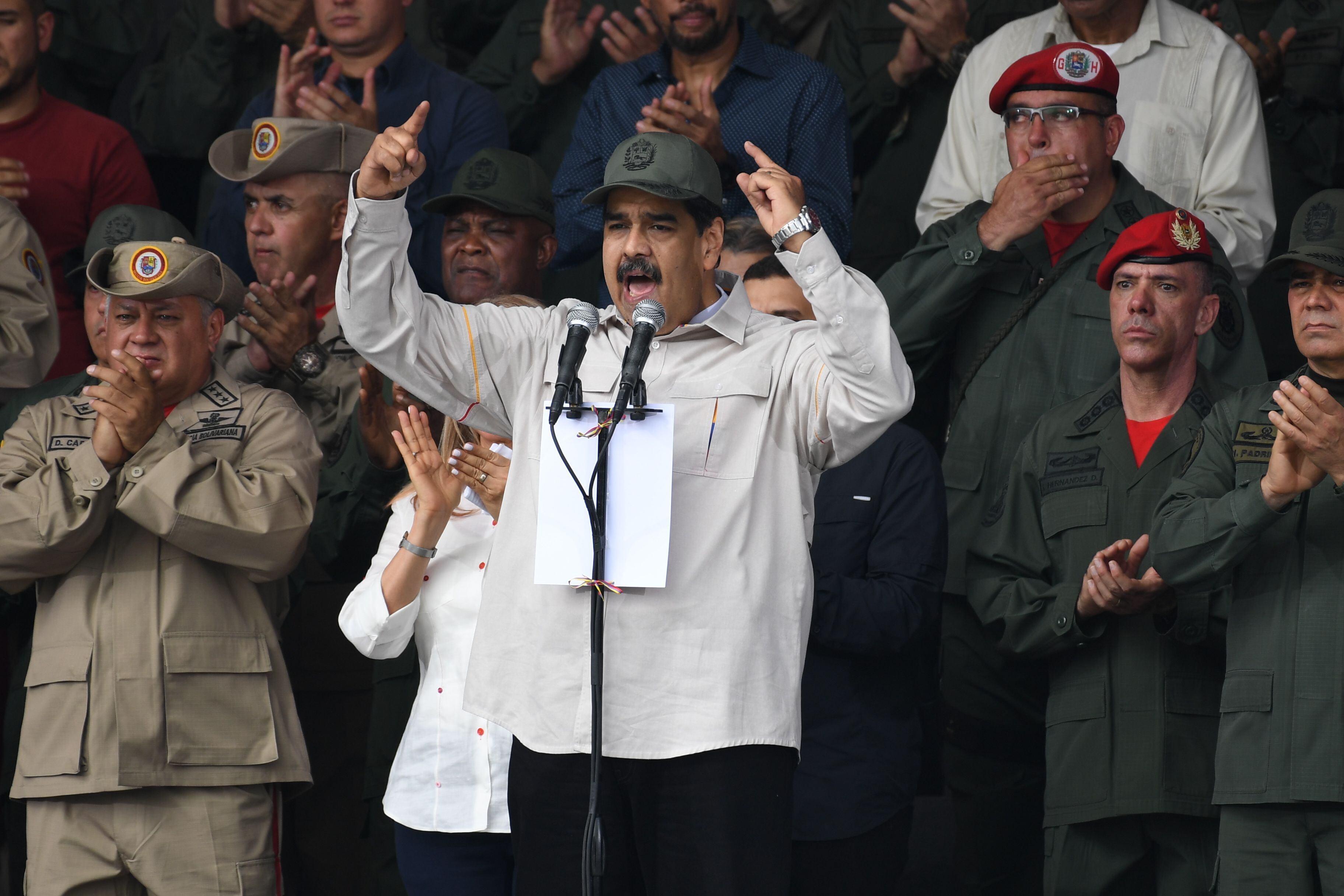 Venezuelan President Nicolas Maduro (C), flanked by the president of the ruling Constituent Assembly Diosdado Cabello (L) and Defence Minister Vladimir Padrino (far R), during a military parade to commemorate the 17th anniversary of a failed 2002 coup d'�tat against former leader Hugo Chavez, at Fuerte Tiuna Military Complex, in Caracas on April 13, 2019. (Photo by Yuri CORTEZ / AFP)