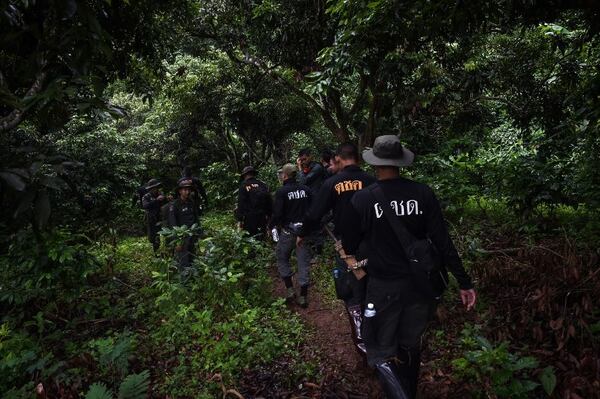   Thai soldiers and policemen walk through the forest to explore a possible opening over Tham Luang Cave in Khun Nam Nang Non-Forest Park, Chiang Rai Province, June 30 2018 children of a football team and their coach. AFP 