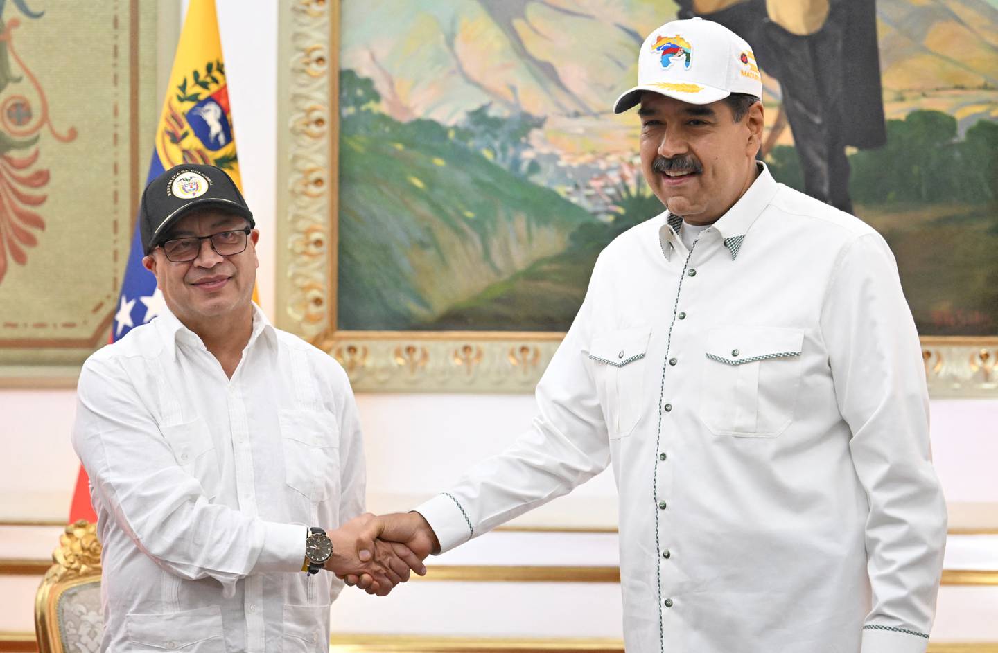 El presidente colombiano Gustavo Petro (izq.) le da la mano a su homólogo venezolano, Nicolás Maduro, durante una visita oficial al Palacio de Miraflores en Caracas.