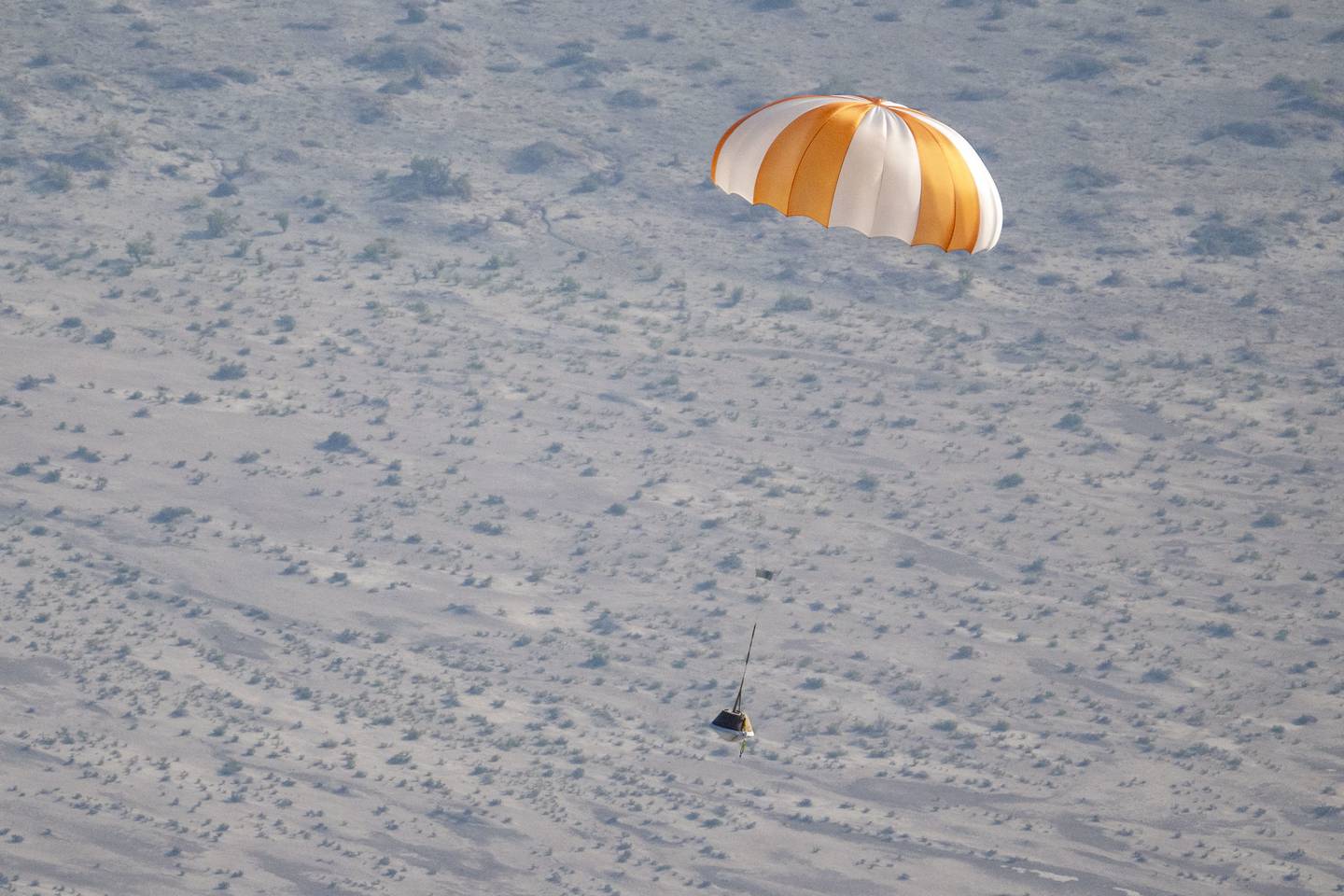 Modelo de entrenamiento de la cápsula OSIRIS-REx en una prueba de caída el 30 de agosto pasado en el Campo de Pruebas y Evaluación de Utah del Departamento de Defensa. Este 24 de setiembre, la cápsula llegó con éxito de la misma manera. Fotografía: NASA.
