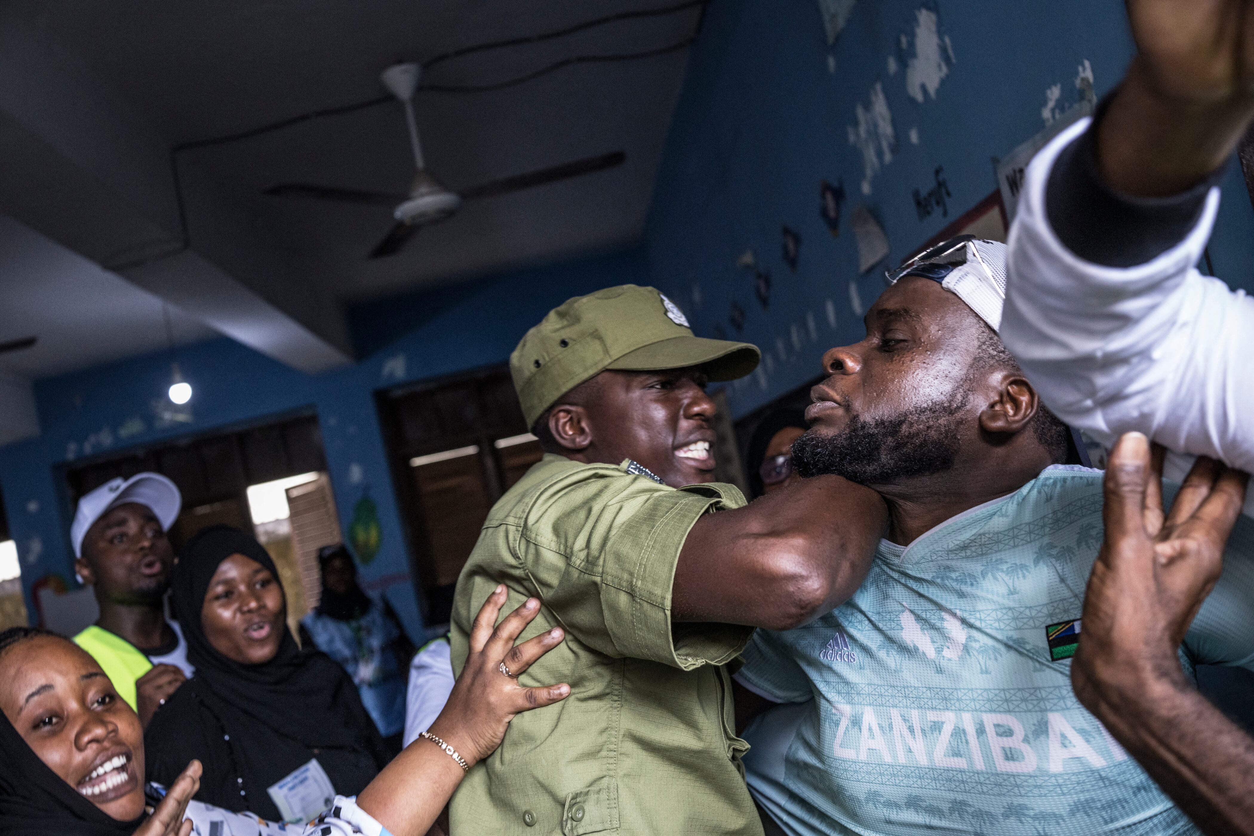 Un agente de policía tanzano detiene a un hombre acusado por funcionarios electorales de intentar enturbiar el proceso de votación en un colegio electoral de Stone Town el 29 de octubre de 2025, durante las elecciones presidenciales de Tanzania.