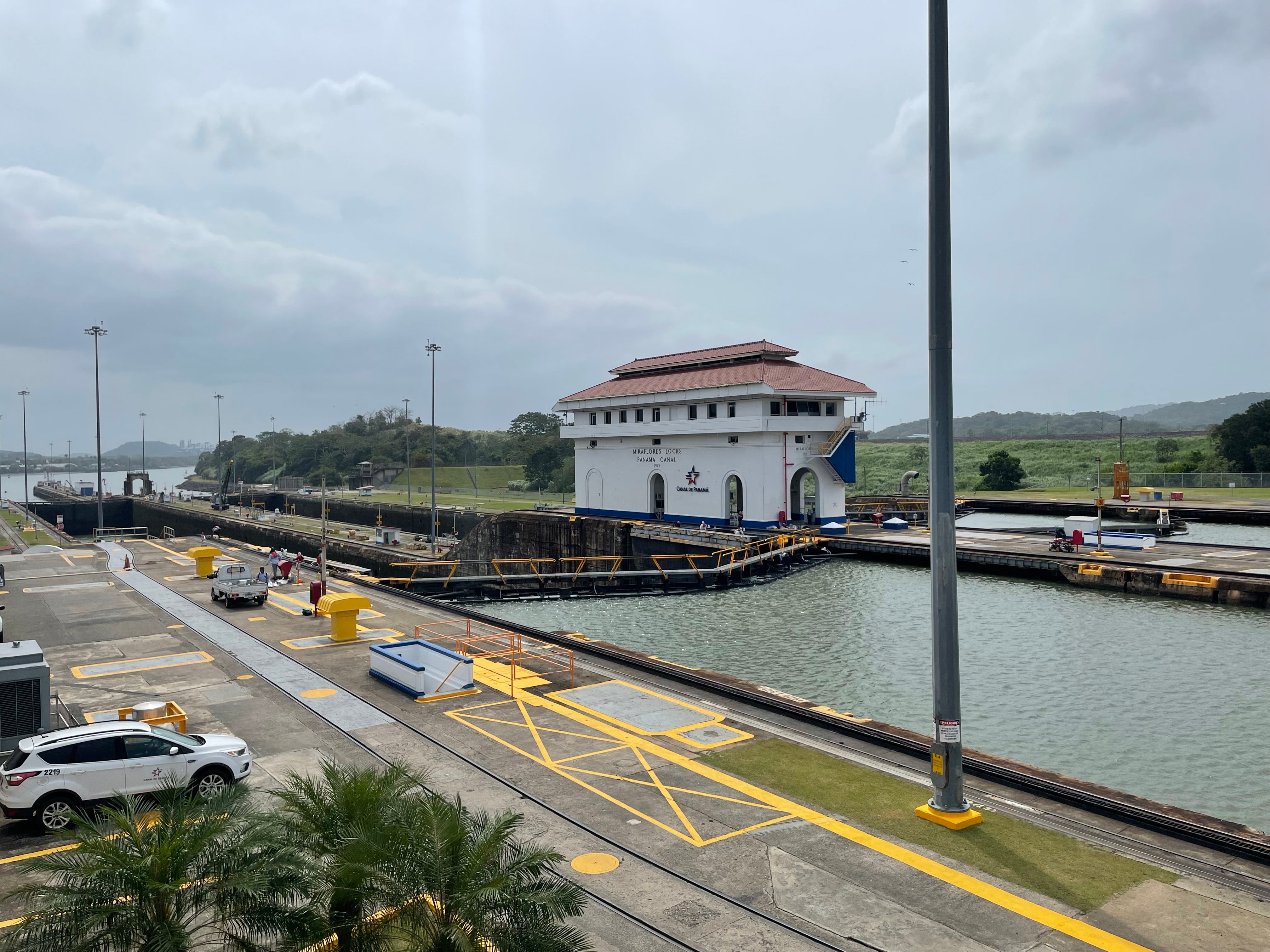Fotografía de las esclusas del Canal de Panamá con una casa de control y el sistema de compuertas operando. Infraestructura esencial para el comercio marítimo mundial.
