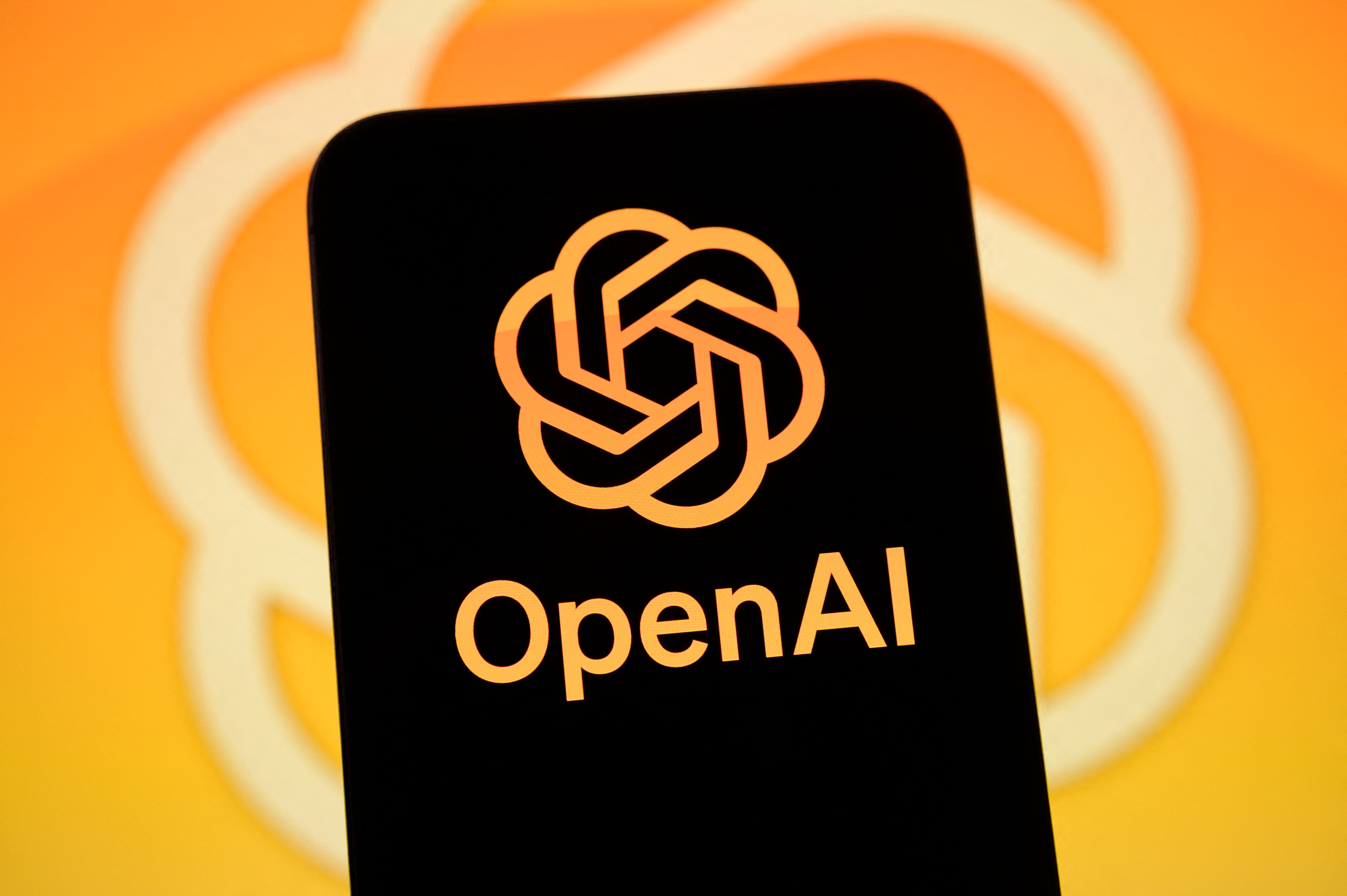 The OpenAI logo is displayed on a smartphone screen with the company icon in the background, in Creteil, France, on May 12, 2026. Daybreak is an AI-powered cybersecurity service designed to detect, analyze, and remediate software vulnerabilities more quickly. (Photo by Samuel Boivin/NurPhoto) (Photo by Samuel Boivin / NurPhoto via AFP)