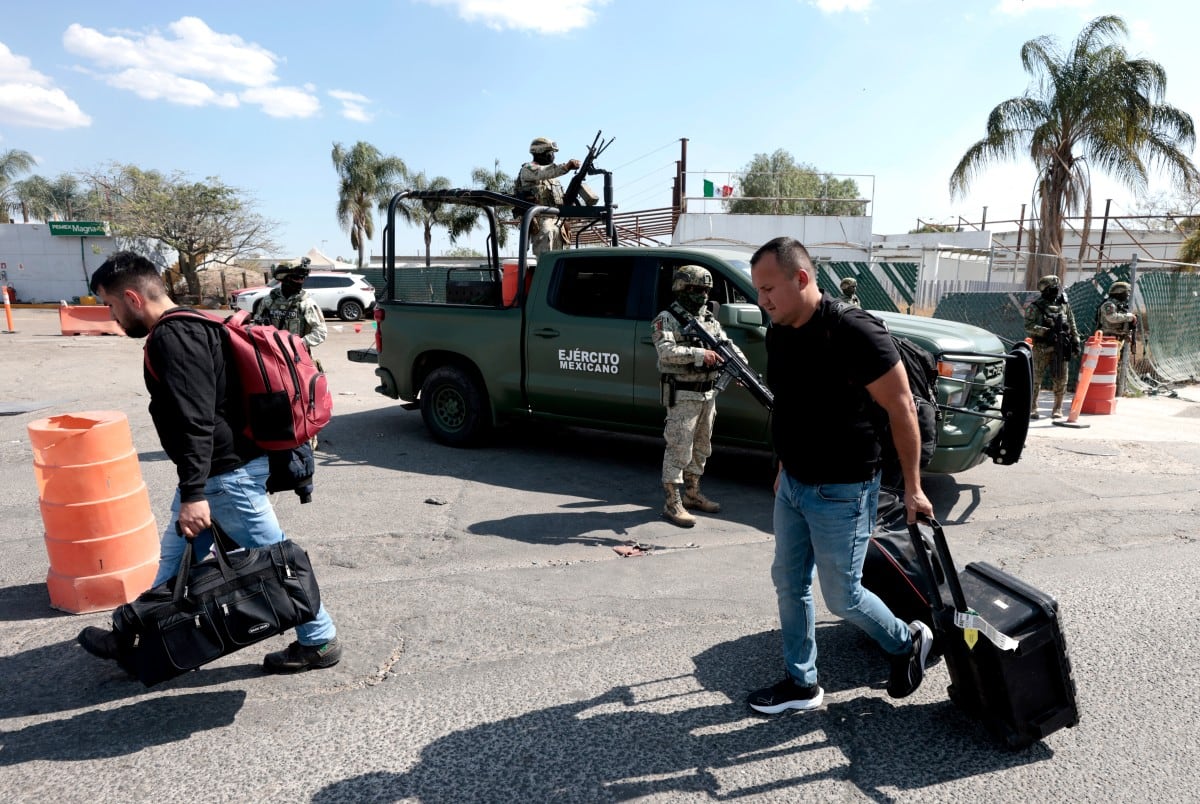 Mexican Army personnel stand guard as passengers leave Guadalajara International Airport in Tlaquepaque, Jalisco State, Mexico, on February 22, 2026. Mexico confirmed on February 22 that soldiers killed a powerful drug cartel leader who was one of the most wanted men here and in the United States.
