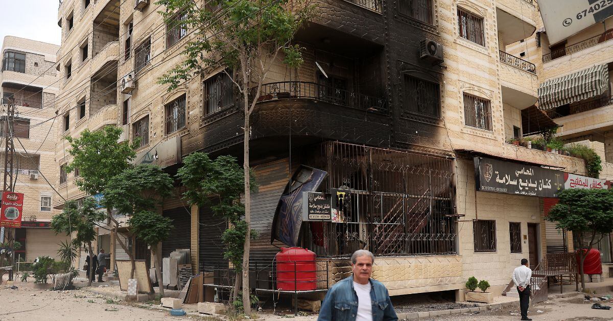 En la imagen la capital de Siria, y un edificio quemado por las bombas