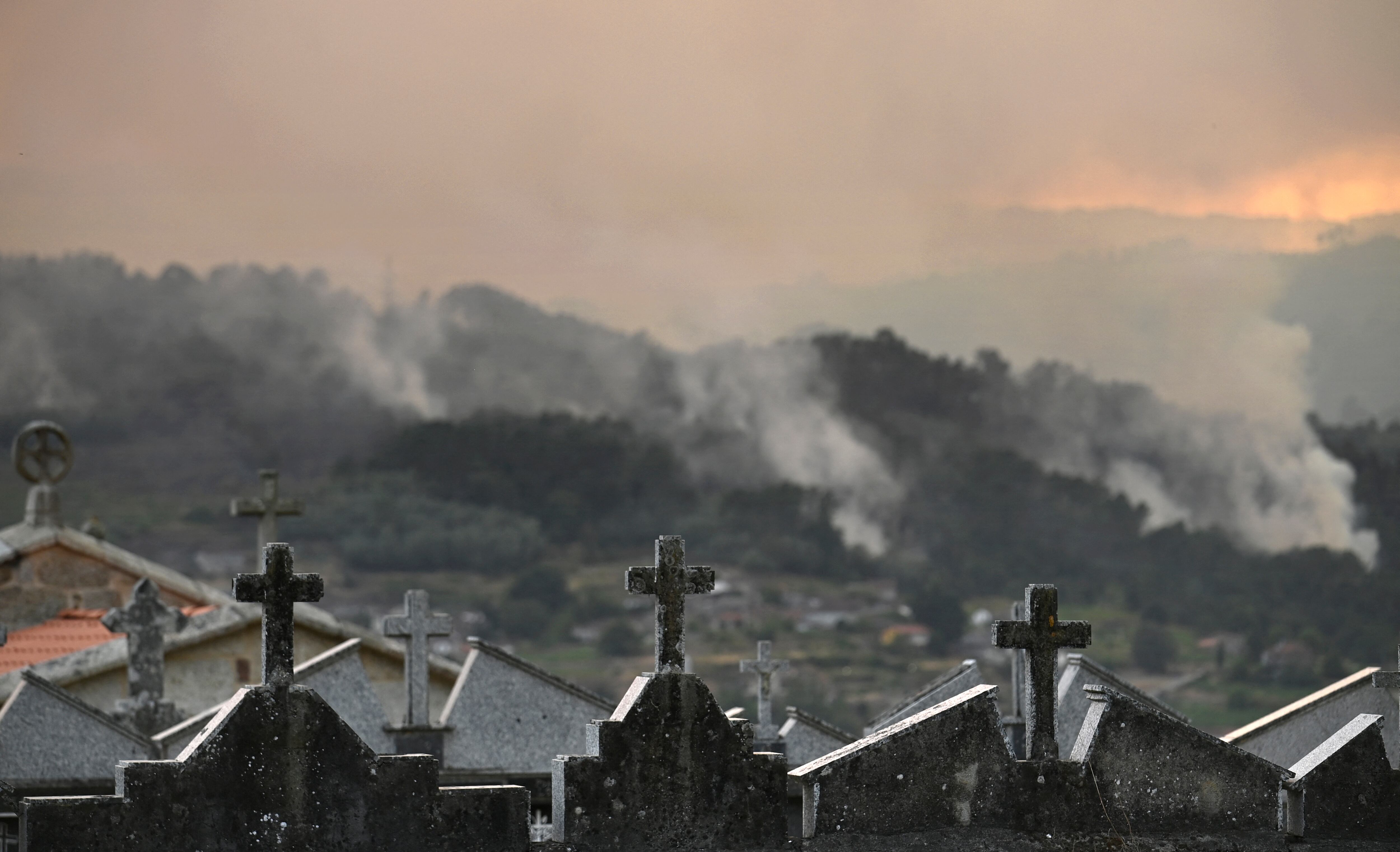 A wildfire burns near the village of Esposende, in the northwestern Spanish municipality of Cenlle, on August 17, 2025. Spain is entering its third week of heatwave alerts and firefighters are continuing to battle blazes in the northwest and west of the country, with army units deployed to help contain the flames. France and Italy had earlier sent water bombers to an air base near Salamanca to help with the firefighting efforts. (Photo by MIGUEL RIOPA / AFP)