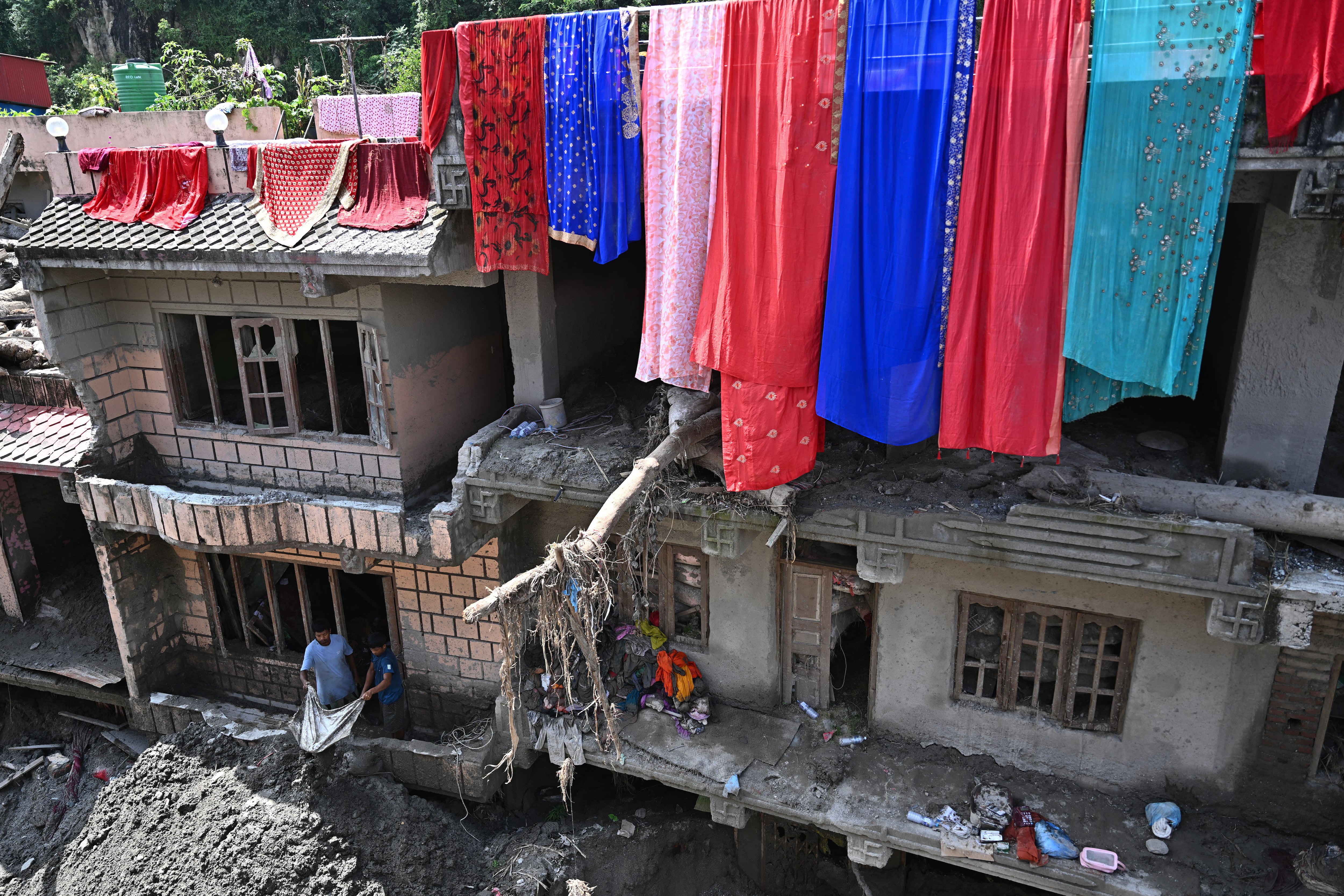 Un hombre limpia una casa en el distrito de Nuwakot en Nepal, luego de la riada que causó 1.398 muertes y más de 5.000 desaparecidos el 26 de agosto.