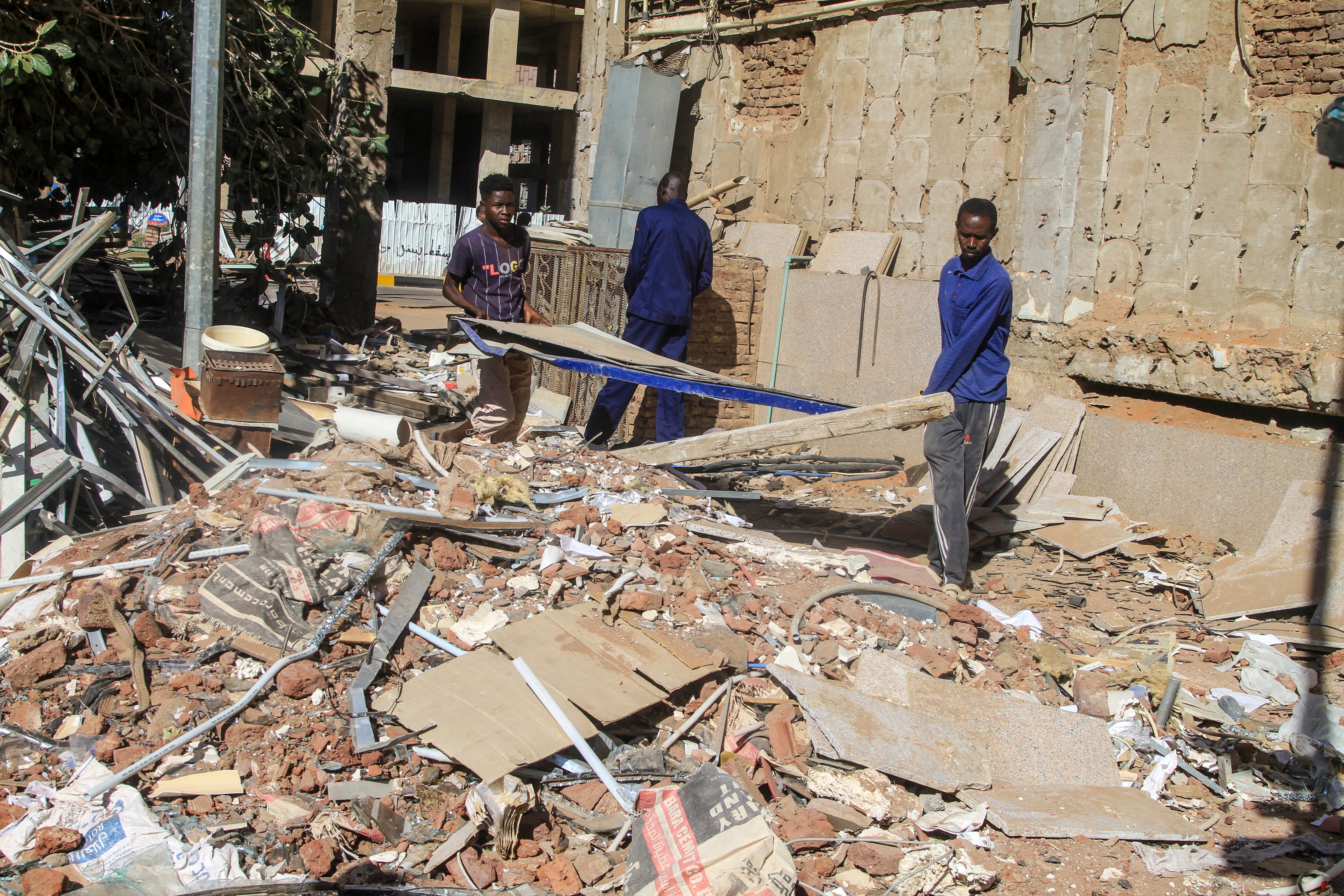 Construction workers remove debris as efforts to restore the city�s infrastructure resume after nearly three years of devastation caused by war, in the capital Khartoum on January 17, 2026. Sudan's Prime Minister announced on January 11, 2026, the government's return to Khartoum, after nearly three years of operating from its wartime capital of Port Sudan. In the early days of the regular military's war with the paramilitary Rapid Support Forces in April 2023, the army-aligned government fled the capital, which was quickly overrun by rival troops. It has pursued a gradual return to Khartoum since the army recaptured the city last March. (Photo by Ebrahim HAMID / AFP)