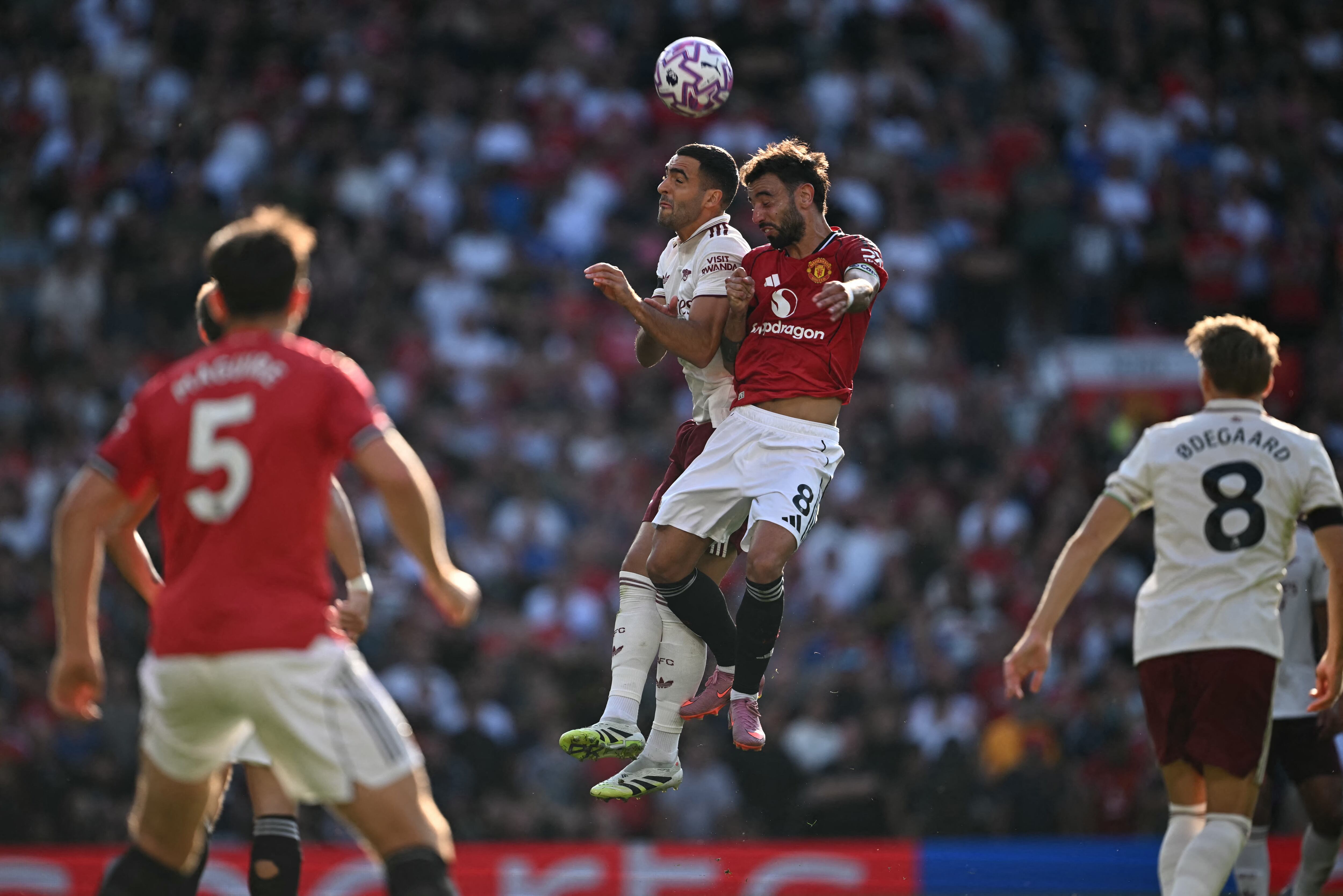 Mikel Merino del Arsenal disputa el balón con el portugués Bruno Fernandes del Manchester United, durante el compromiso por la Liga Premiere en Old Trafford.