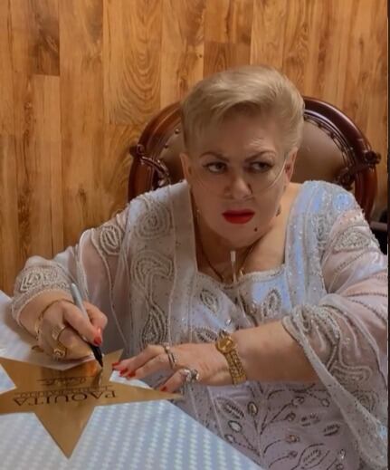 Imagen de Paquita la del Barrio usando una cánula nasal durante una firma de autógrafos.