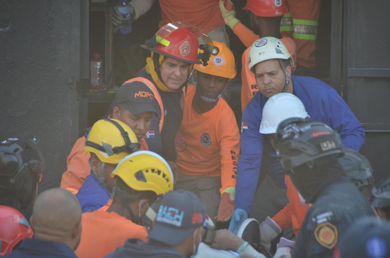 Socorristas al momento de realizar un cordón humano mientras intentan rescatar a uno de los heridos de desplome.