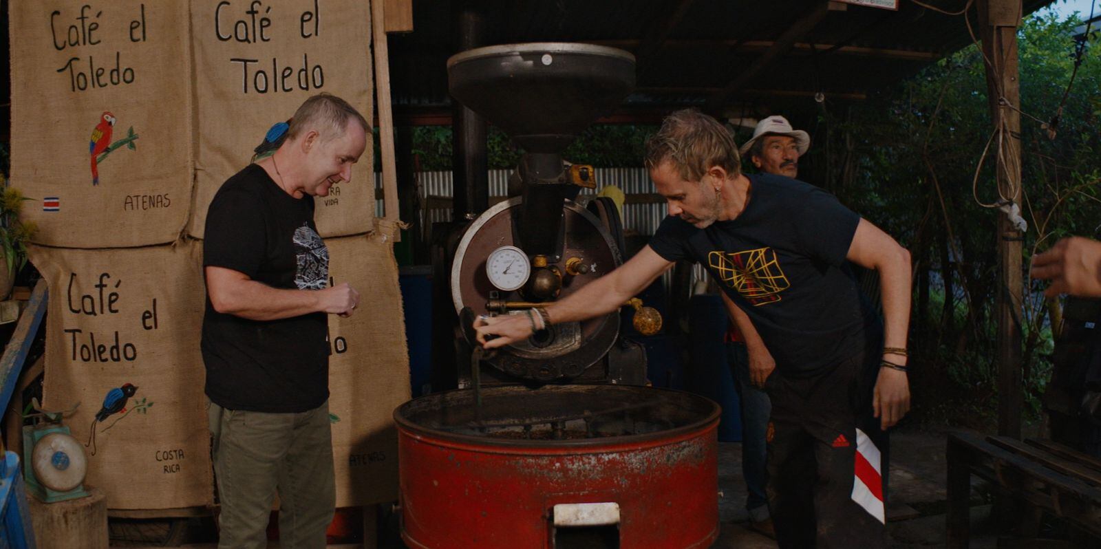 Durante su paso por Alajuela, Boyd y Monaghan visitaron la finca El Toledo, donde aprendieron sobre el proceso artesanal de producción de café costarricense.
Texto alternativo (Alt Text): Billy Boyd y Dominic Monaghan observan el proceso de tostado de café en la finca El Toledo en Alajuela, como parte de su recorrido por Costa Rica para la serie "Billy & Dom Eat The World".