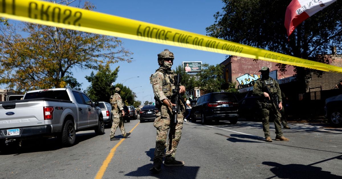 Agentes de la Patrulla Fronteriza (CBP) de Estados Unidos enmascarados permanecen detrás de una línea policial mientras residentes del vecindario de Brighton Park, en Chicago, confrontan a las fuerzas del orden en una gasolinera tras la presunta detención, por parte de agentes de Inmigración y Control de Aduanas (ICE), de un hombre no identificado que viajaba en su automóvil, en Chicago, Illinois, el 4 de octubre de 2025.
