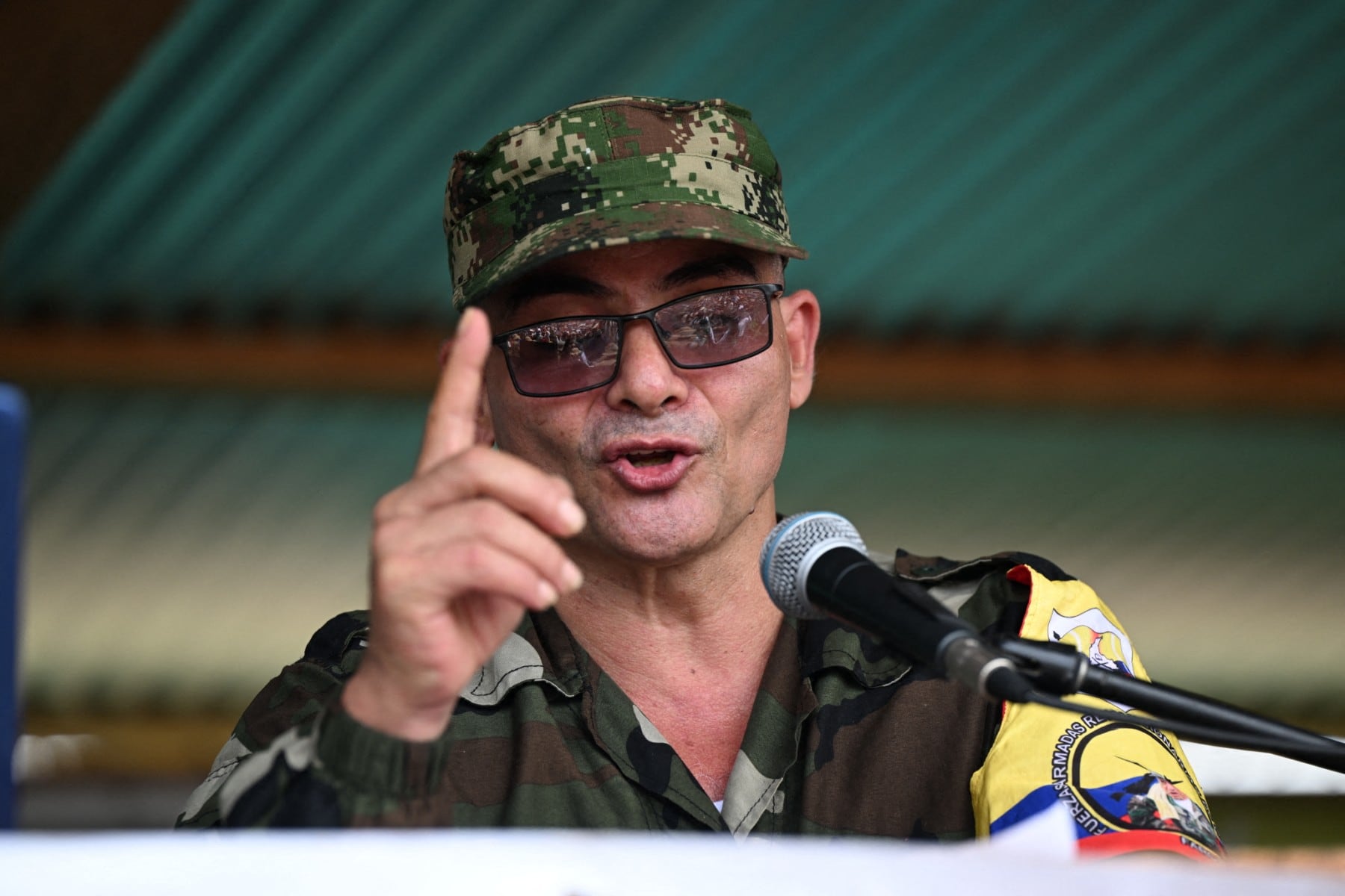 FARC-EP dissidence top commander, aka Ivan Mordisco (C), speaks during a meeting with local communities in San Vicente del Caguan, Caqueta department, Colombia, on April 16, 2023. An armed dissident group of Colombia's disbanded FARC guerrillas said Sunday it was "ready" to start peace talks with the government from May 16. "We are announcing to the world that our delegates to the dialogue table with the Colombian government... are ready for May 16," the EMC dissident grouping, which rejected a 2016 peace deal that disarmed the FARC, said through a spokesperson. (Photo by JOAQUIN SARMIENTO / AFP)