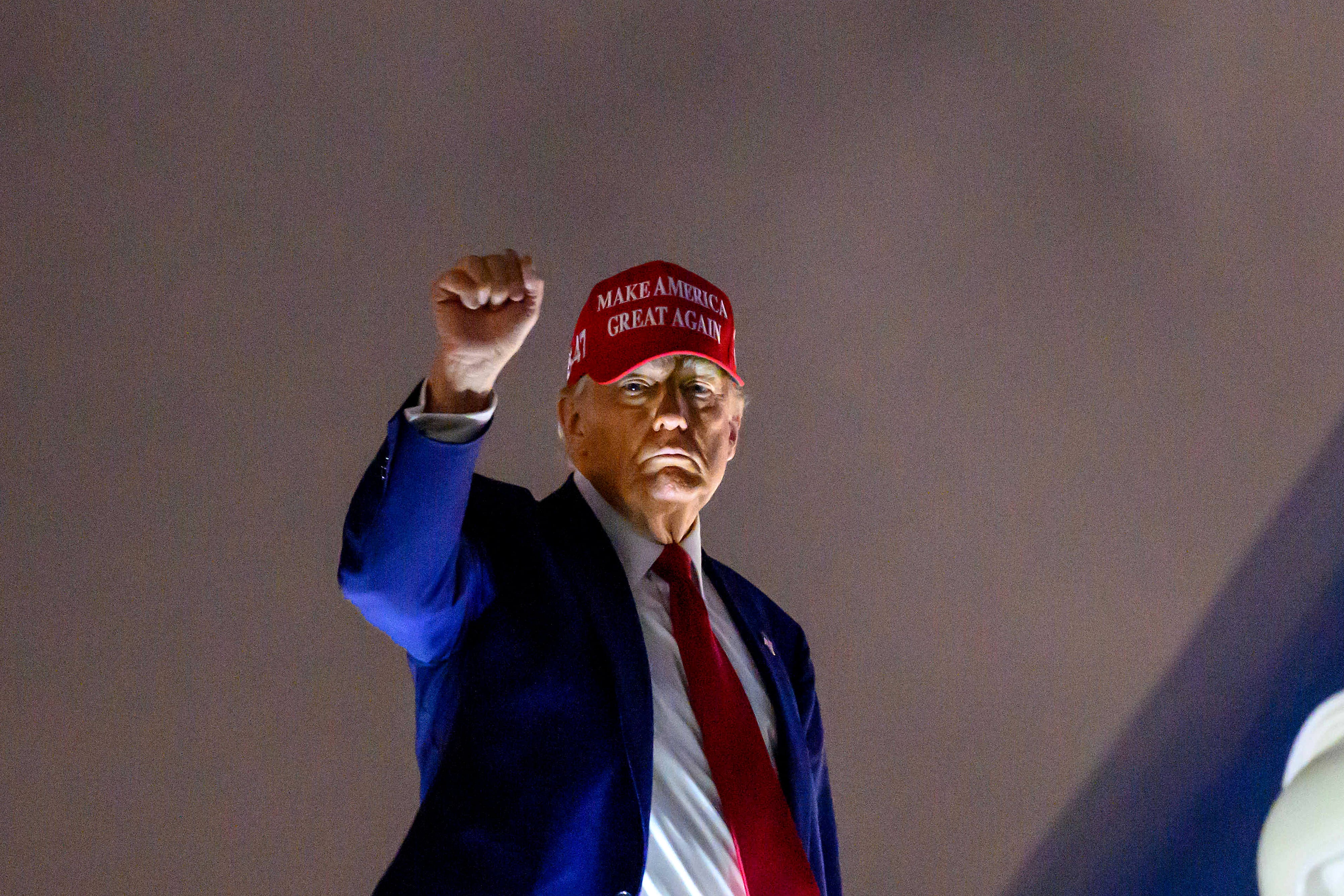 US President Donald Trump pumps his fist upon arrival at Miami International Airport on April 3, 2025. Trump is travelling to the Trump National Doral Golf Club before going to his Mar-a-Lago Resort. (Photo by Mandel NGAN / AFP)