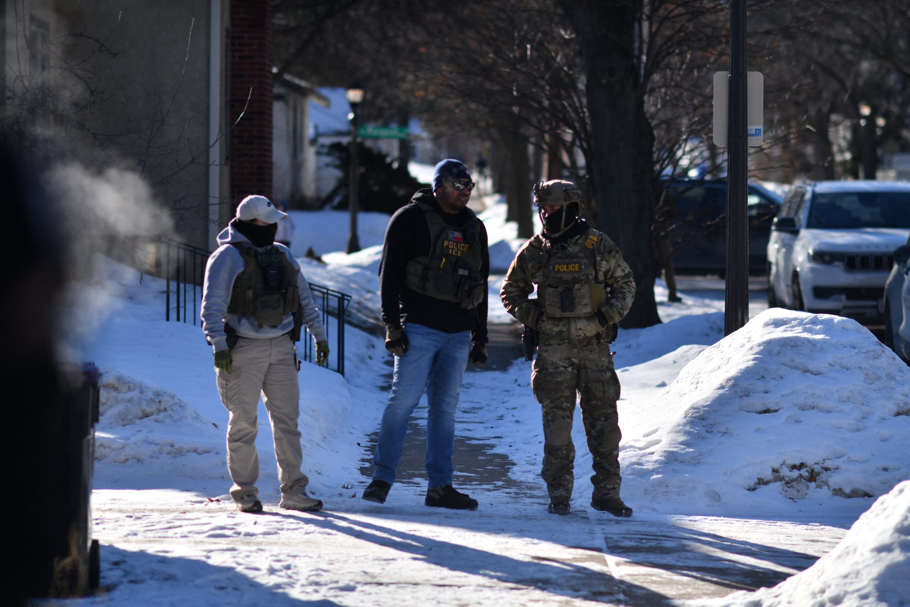 ICE agents block an intersection during an immigration enforcement operation in a St. Paul, Minnesota, neighborhood following a multi-vehicle accident on January 31, 2026. Donald Trump's border chief said January 29, 2026 that some federal agents could be withdrawn from Minneapolis, the northern US city that has become the flashpoint for the president's immigration crackdown. The Trump administration, facing a public backlash over the shooting deaths of two Americans by federal agents in Minneapolis, also eased immigration operations in the northeastern state of Maine. (Photo by Octavio JONES / AFP)