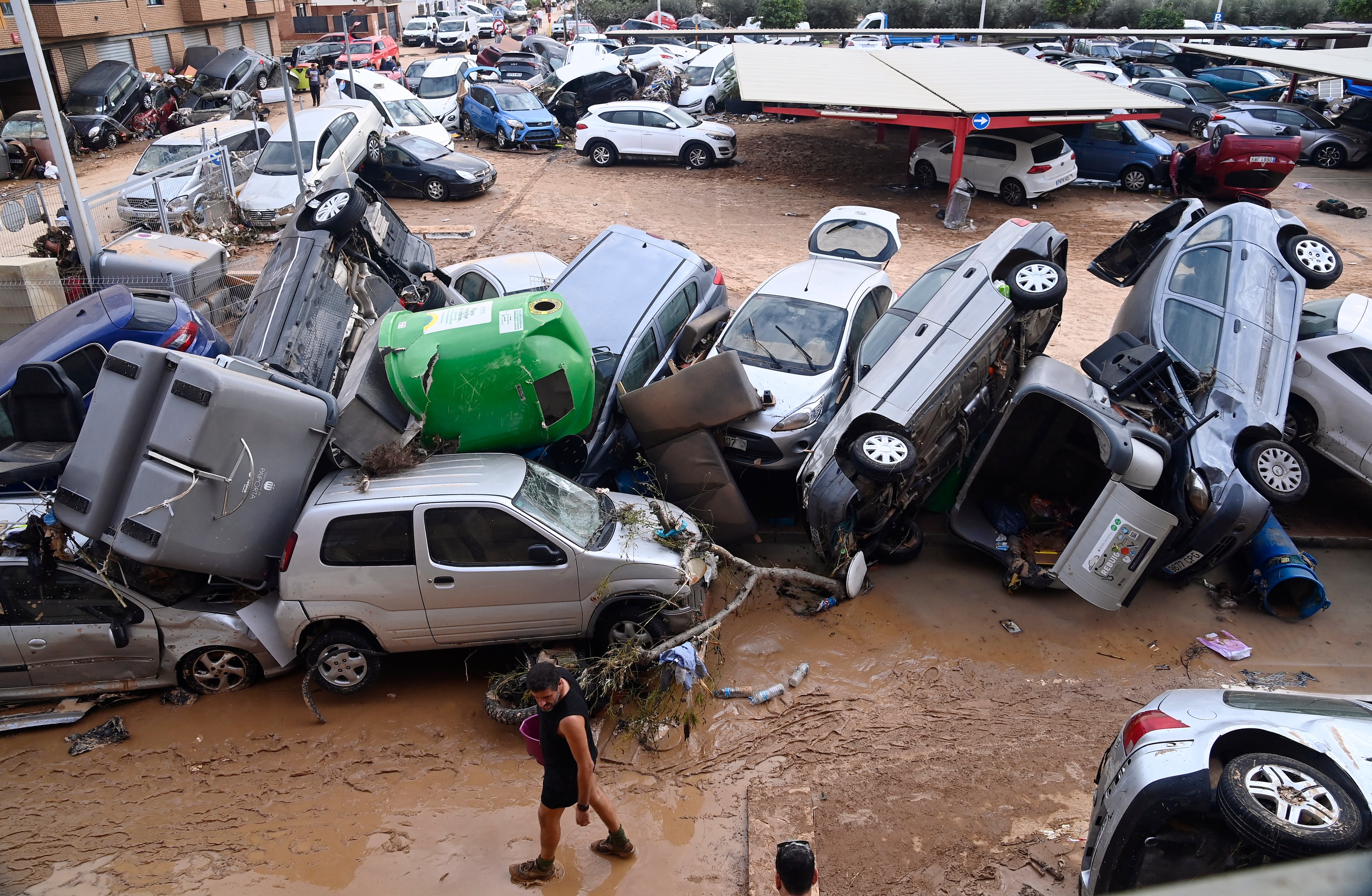 Carros y escombros cubiertos de barro en Paiporta tras las históricas inundaciones en Valencia. Foto: JOSE JORDAN / AFP
