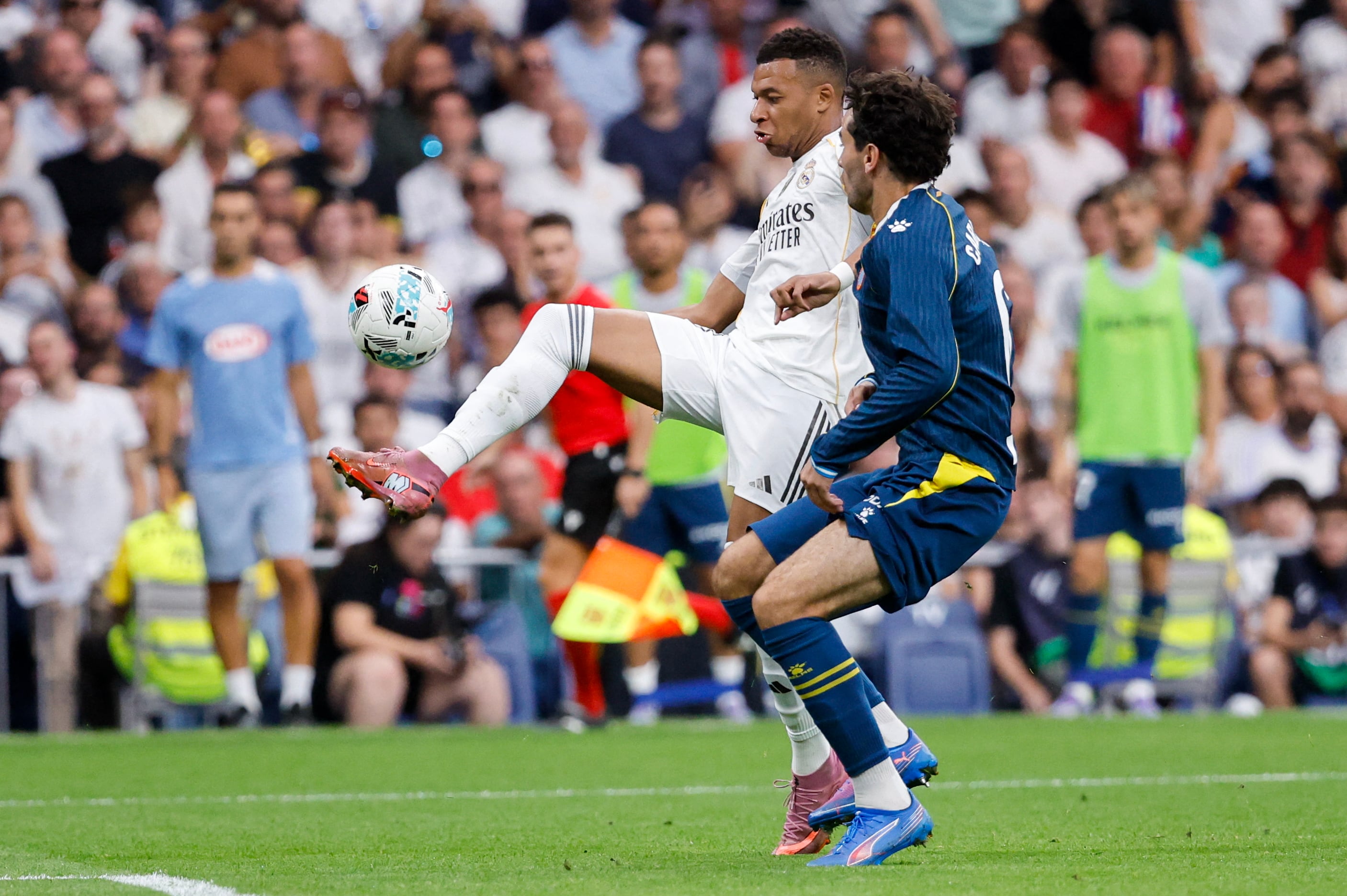 El delantero del Real Madrid Kylian Mbappé trata de superar la marca de Leandro Cabrera del Espanyol, durante el compromiso por la Liga Española.