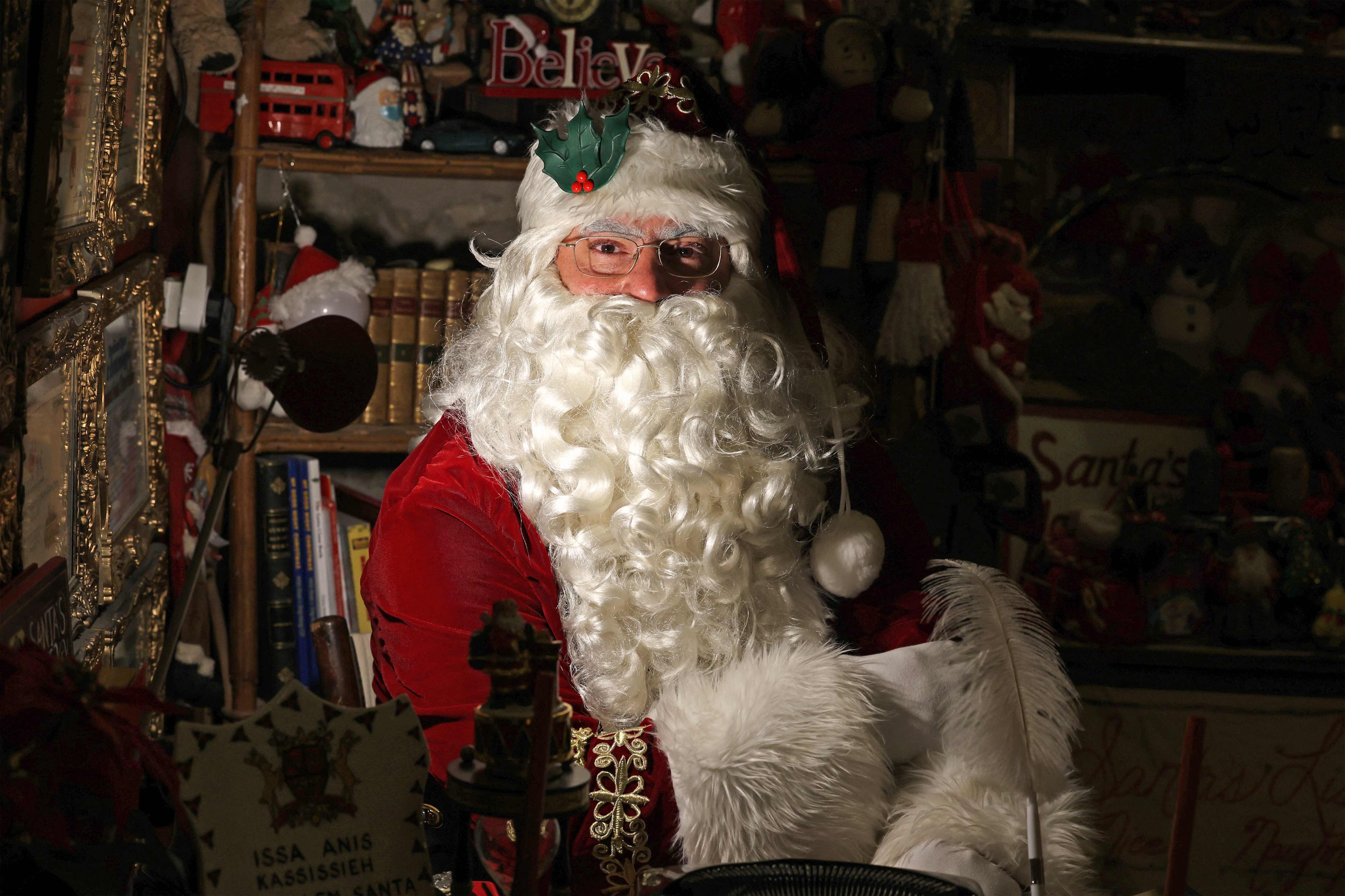 Santa Claus en su taller rodeado de juguetes y decoraciones navideñas.
