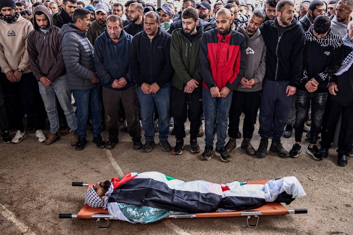 Dolientes rezan ante el cuerpo de Amir Mutasem Odeh, un palestino de 28 años que, según informes, murió en un ataque de colonos israelíes el día anterior, durante el funeral en la aldea de Qusra, al sur de Nablus, en la Cisjordania ocupada.