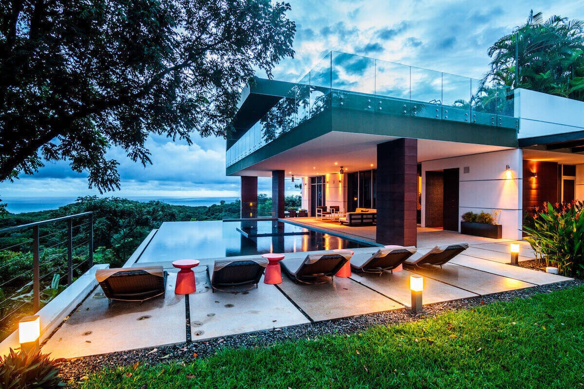 Casa moderna con piscina infinita y vista al mar en una zona costera del Pacífico de Costa Rica, reflejando el alto costo de construcción en la región.