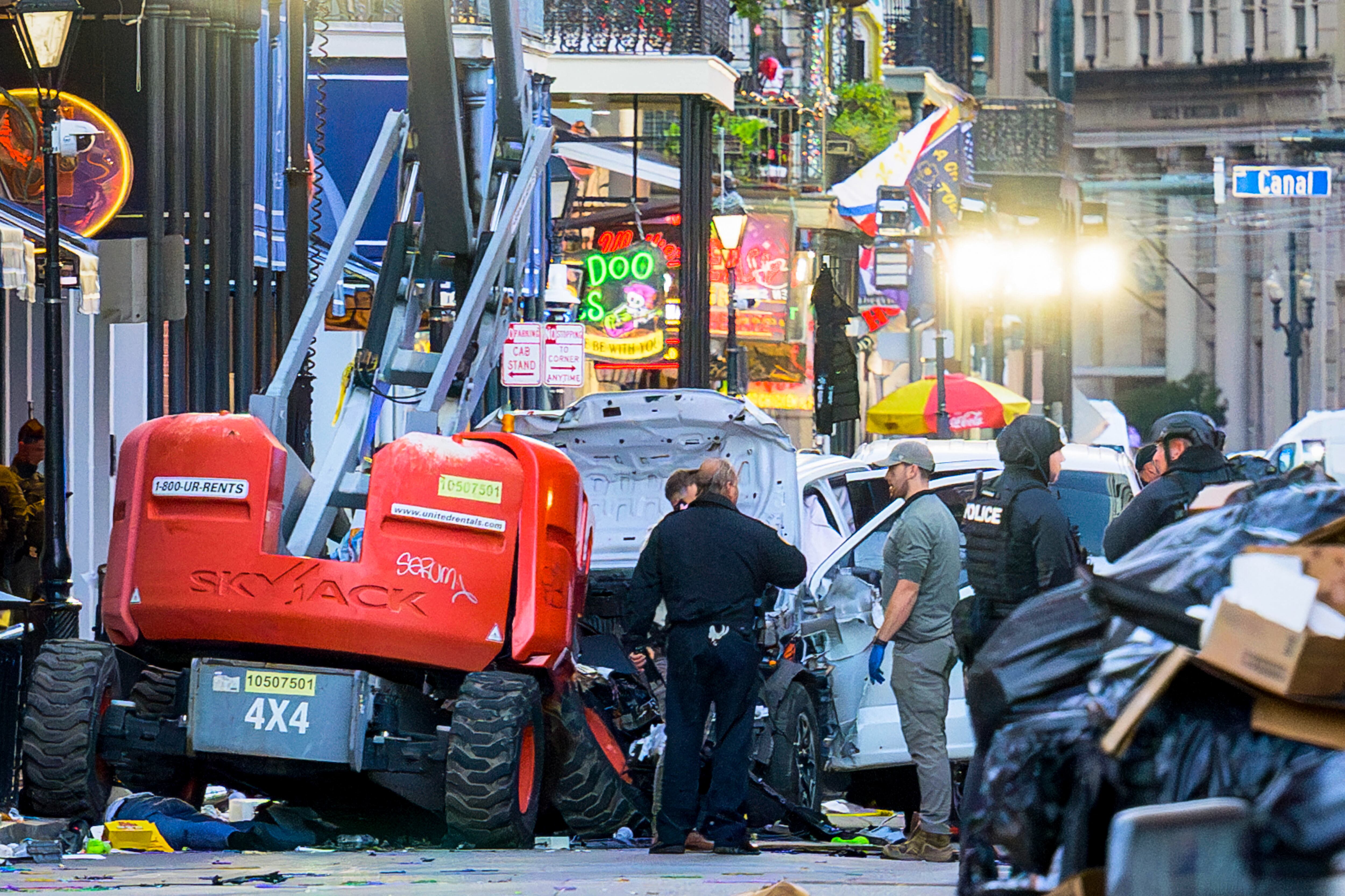 EDITORS NOTE: Graphic content / Police investigators surround the white Ford F-150 pickup truck that crashed into a work lift after allegedly driving into a crowd of New Year's revelers in the French Quarter of New Orleans, Louisiana, on January 1, 2025. At least 10 people were killed and 30 injured Wednesday when a vehicle plowed overnight into a New year's crowd in the heart of the thriving New Orleans tourist district, authorities in the southern US city said. (Photo by Matthew HINTON / AFP)