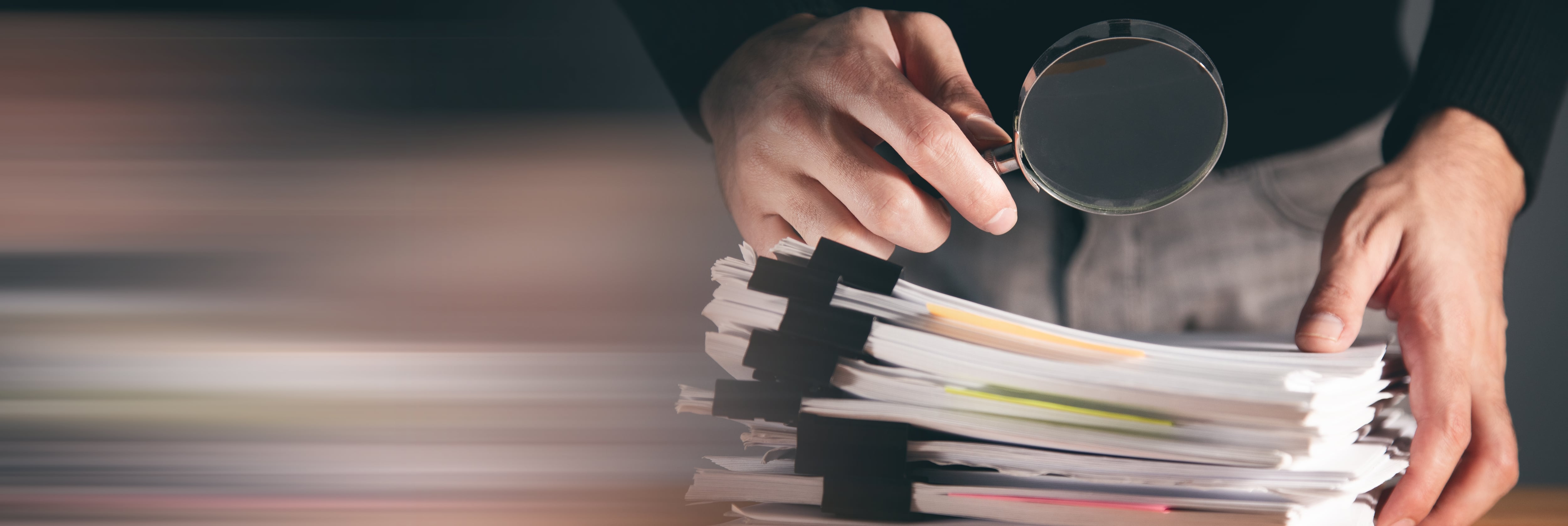 Rendición de cuentas, manos sosteniendo una lupa sobre documentos oficiales