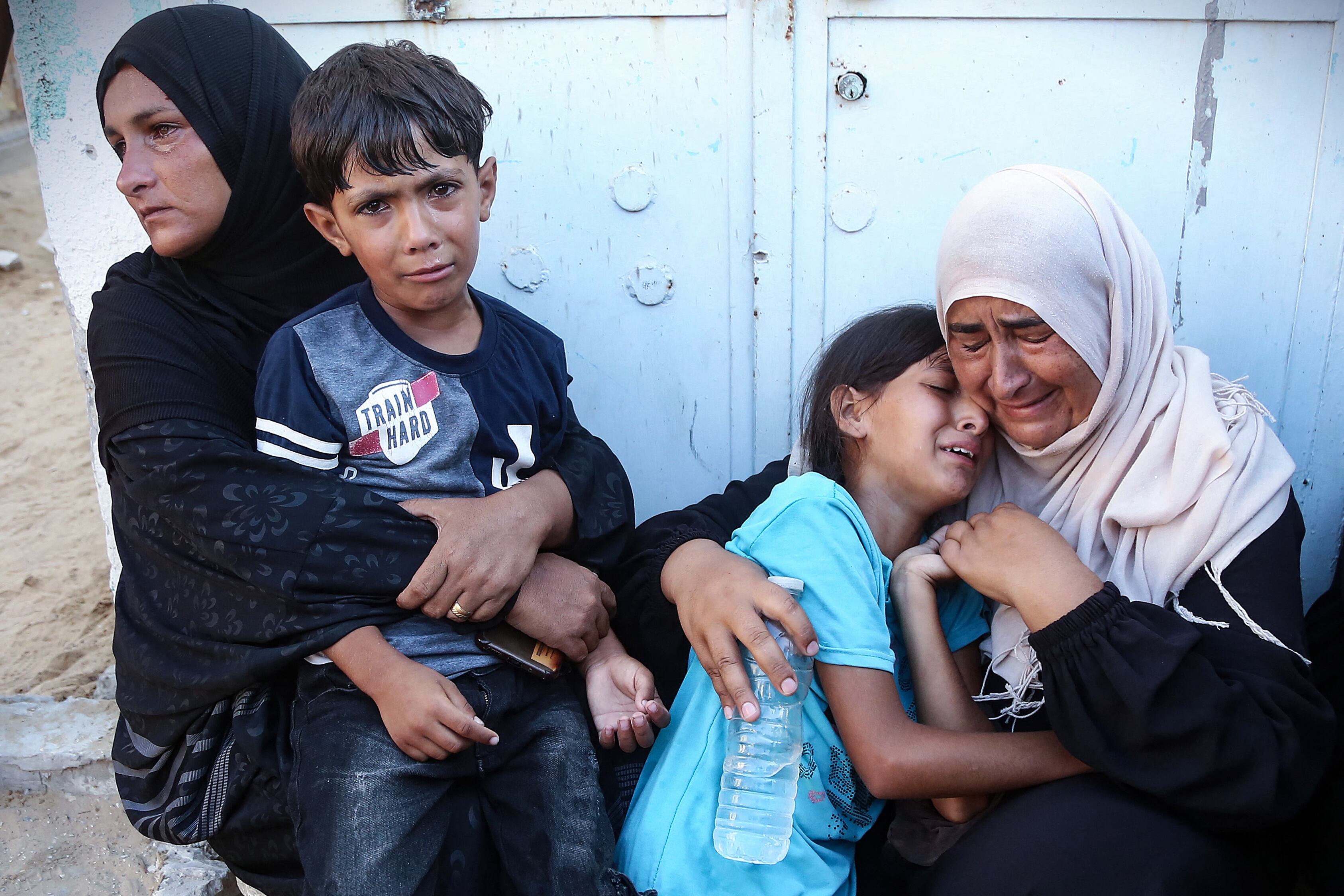 Mujeres y niños reaccionan luego de identificar cuerpos de familiares entre las víctimas de disparos de Israel en el campo de refugiados al-Mawasi, en Gaza.
