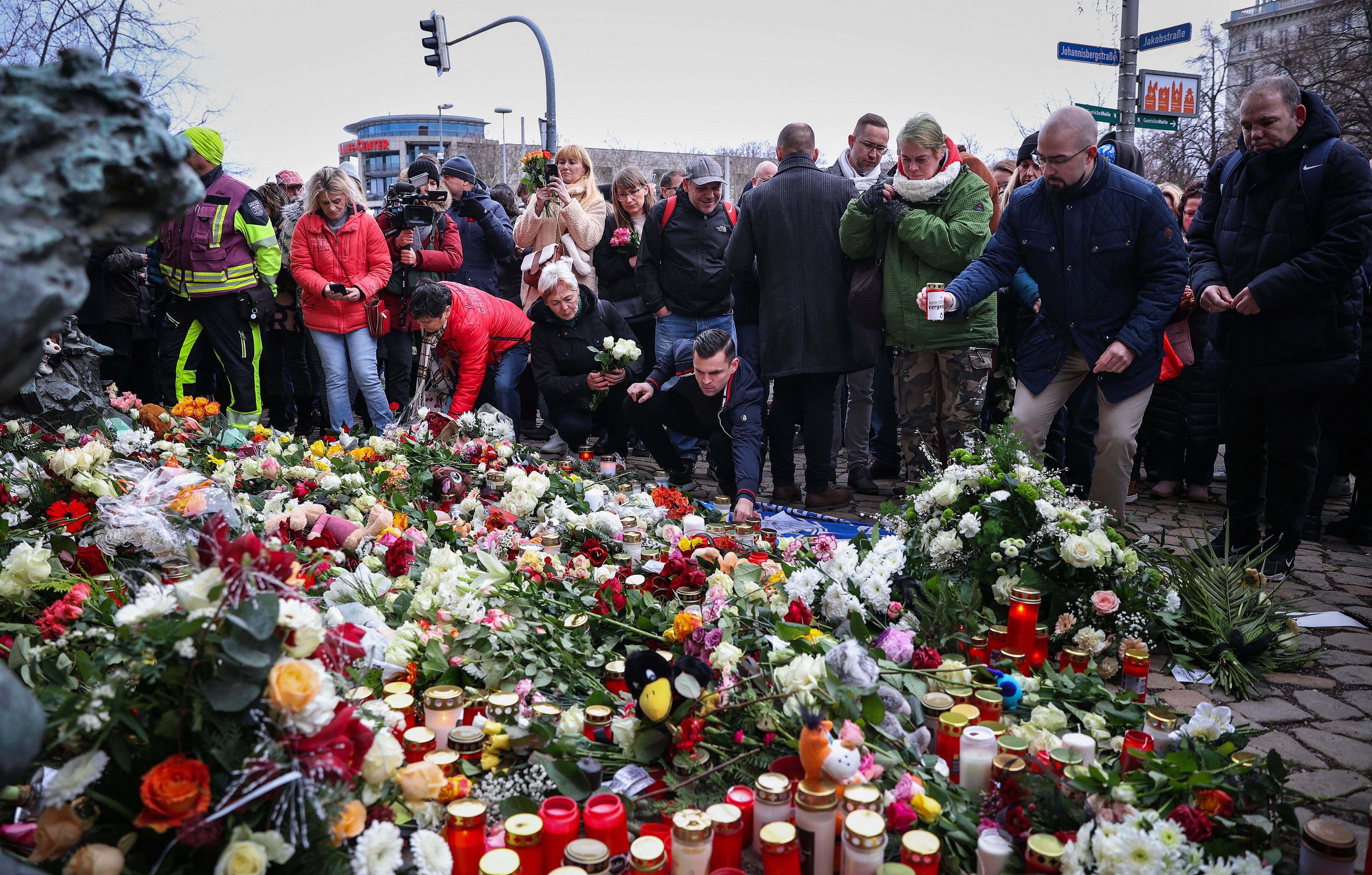 Personas solidarias depositan flores cerca del lugar del ataque con vehículo ocurrido en un mercado navideño en Magdeburgo, al este de Alemania, el 21 de diciembre de 2024, que resultó en varias muertes y decenas de heridos. El número de fallecidos por el ataque del 20 de diciembre aumentó a 5 el 21 de diciembre de 2024, con más de 200 heridos, según informó el jefe del gobierno regional, Reiner Haseloff.