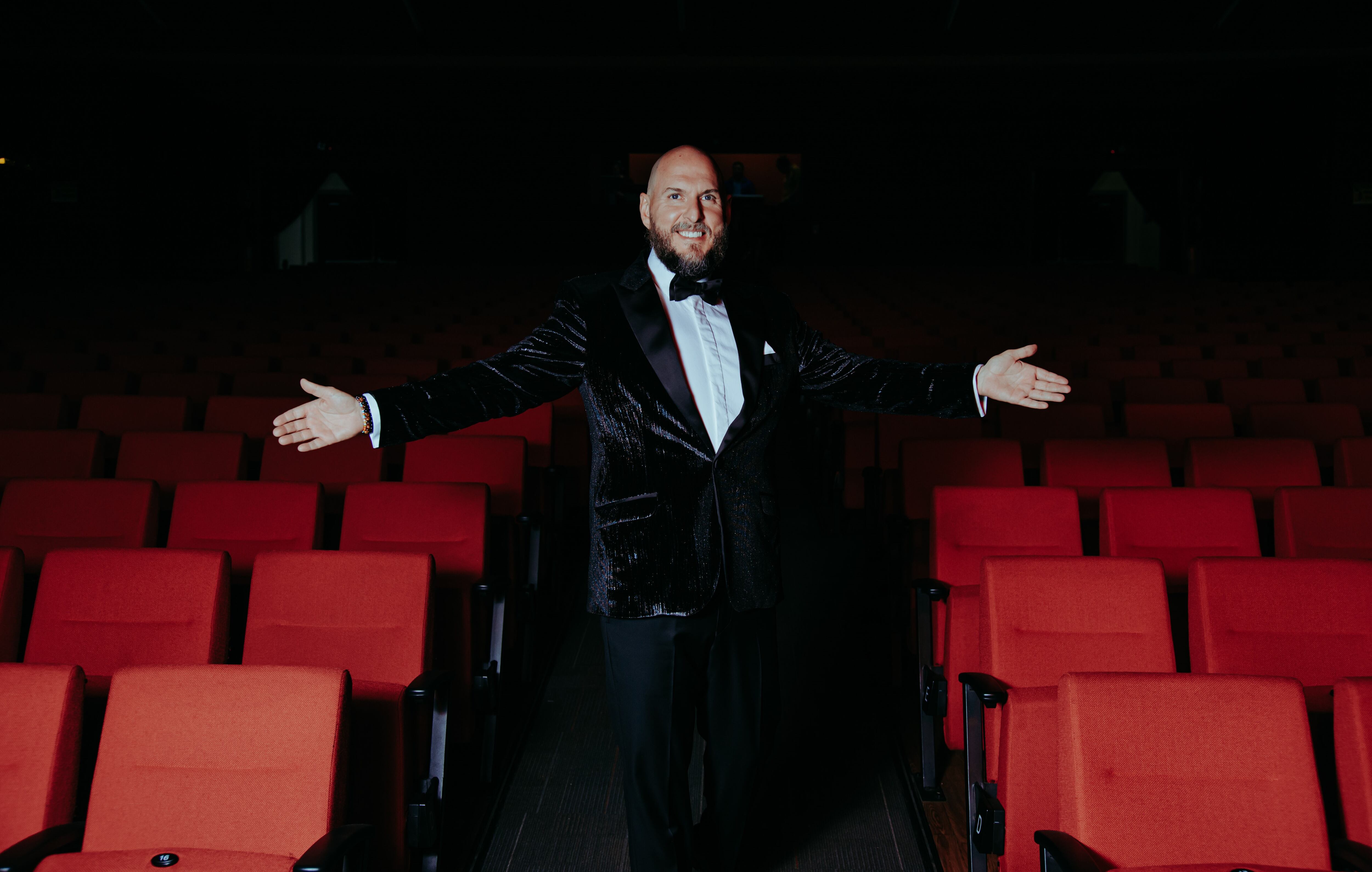 El actor colombiano Andrés Parra posando en medio de las butacas de un teatro.