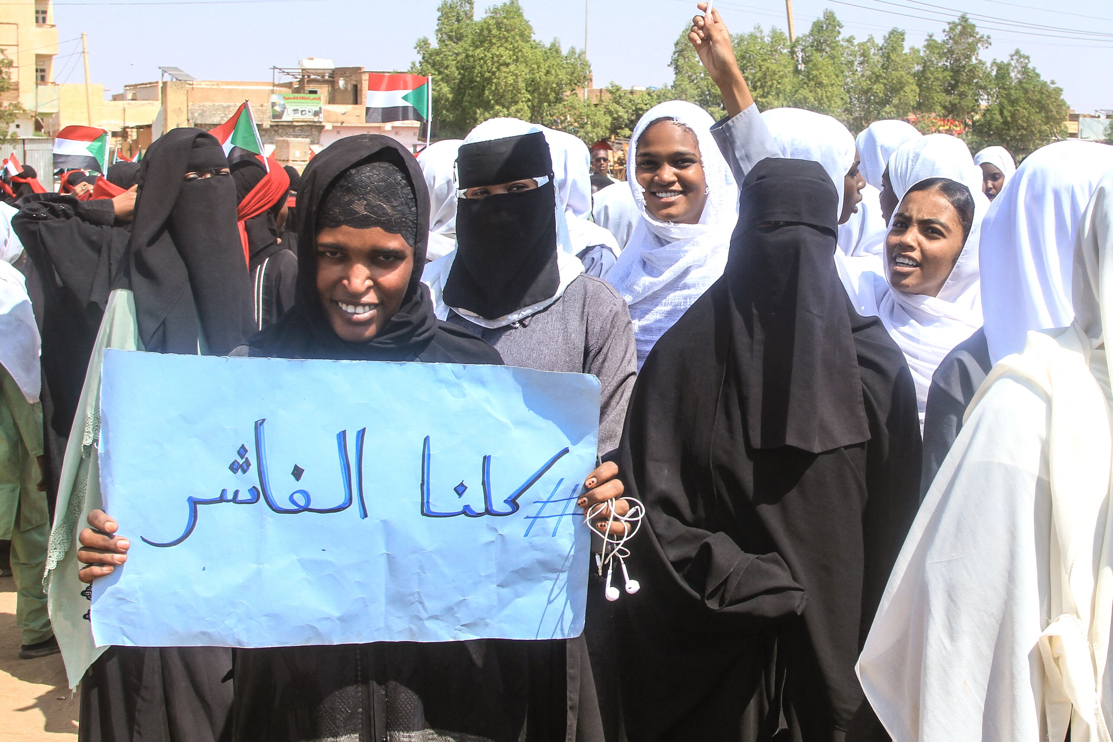 Un estudiante sudanesa de una escuela en la región de Nilo Oriental, en la capital, sostiene un cartel que dice en árabe: "Todos somos El-Fasher" durante una protesta contra las violaciones cometidas por las Fuerzas de Apoyo Rápido (RSF) contra la población de El-Fasher, en Jartum, el 3 de noviembre de 2025.
