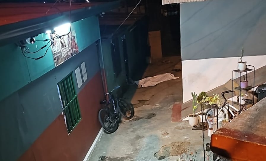 Agentes de la Fuerza Pública de Costa Rica mantienen operativos en Cerro Bonito, Alajuelita, tras un enfrentamiento que dejó una persona fallecida (imagen al fondo).